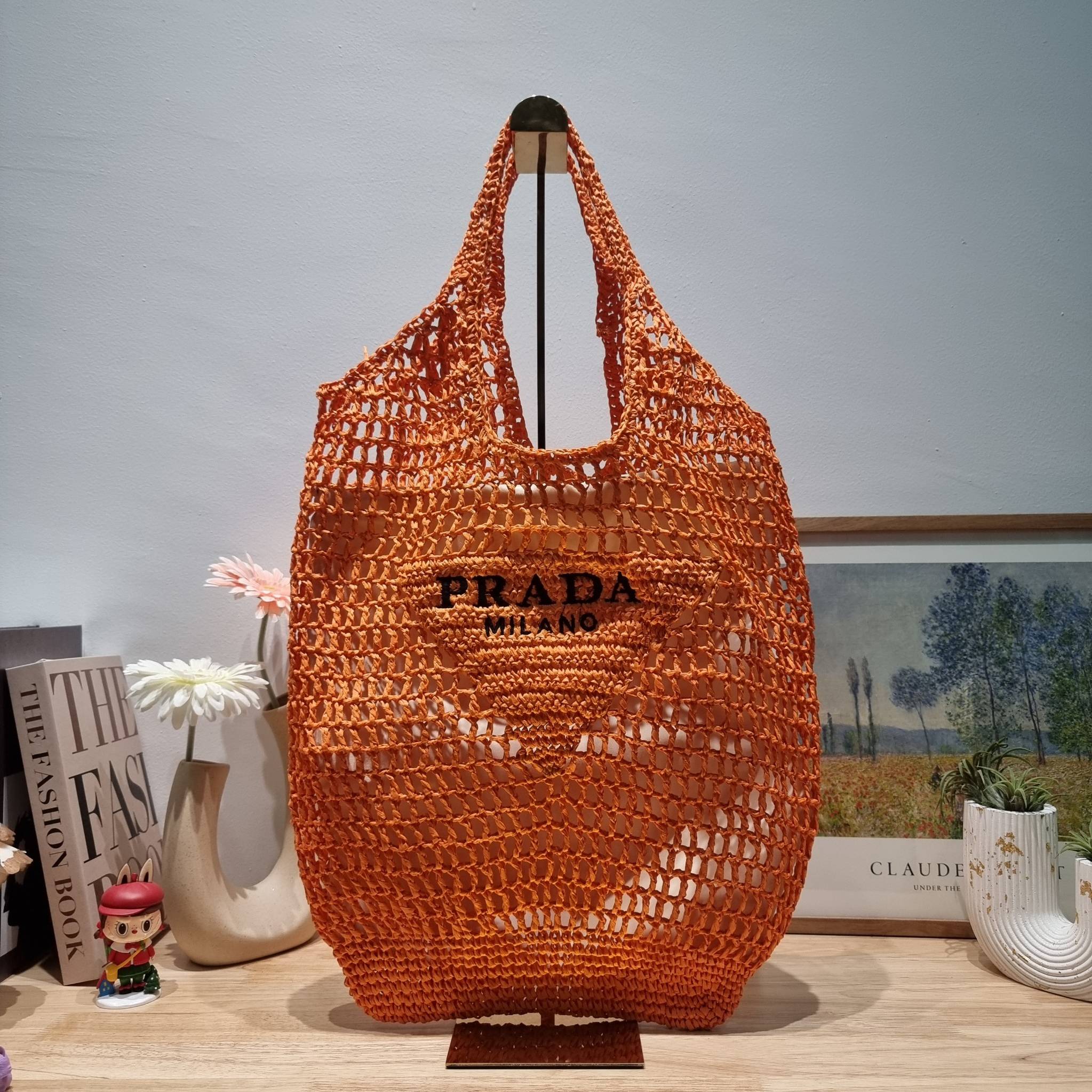 PRADA RAFFIA TOTE BAG สวยไม่ซ้ำใคร สไตล์บีช เหมาะมากกับการสะพายไปเที่ยวทะเล หรือจะใช้ในวันสบายๆก็ตอบโจทย์ กับกระเป๋าสะพายสานใบใหญ่ ตัวกระเป๋าเป็นวัสดุสังเคราห์จากธรรมชาติ สานทอเต็มใบออกมาเป็นลวดลายสวยงาม