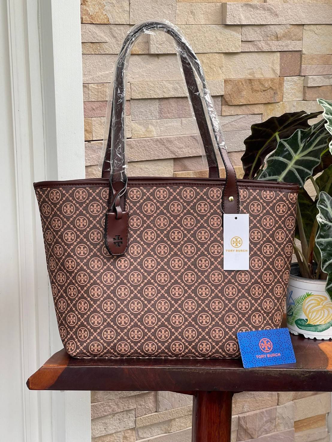 OUTLET 】Tory burch T Monograme Large shopping bag กระเป๋าสะพายใบไหล่ใบใหญ่ โดยตัวกระเป๋าทำมาจากผ้าแคนวาสเคลือบผิวด้านทนต่อรอยขีดข่วนได้เป็นอย่างดี ขนาดที่ใหญ่สามารถใส่ได้ทั้งเอกสารและสัมภาระต่างๆ พร้อมด้วยซิปปิดกระเป๋าด้านบนจึงเป็นอีกรุ่นที่เหมาะกับสาวออฟ