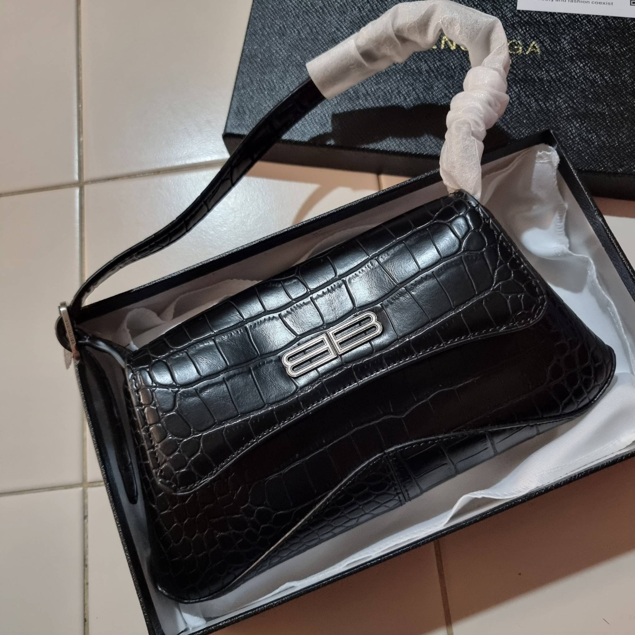 Balenciaga XX small flap bag กระเป๋าสะพายดีไซน์สวยเลิศ!! ไม่ซ้ำ เอกลักษณ์ที่โดดเด่นด้วยรูปทรง และขนาดที่กำลังเหมาะใช้งาน พร้อมดีไปหมด!! วัสดุหนังลายจระเข้ ขึ้นเงาคมชัด เปิด-ปิดด้วยกระดุมแม่เหล็ก ภายในกระเป๋าเป็นช่องโล่ง ใส่ของสำคัญจุกจิกพอได้ พกพาได้แบบไม