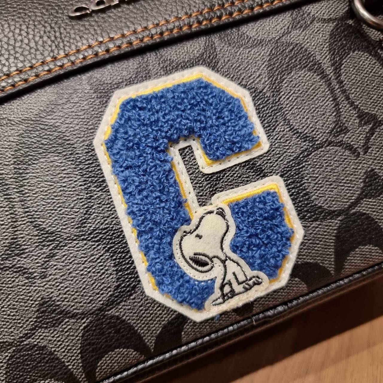 COACH C4027 COACH x PEANUTS GRAHAM CROSSBODY IN SIGNATURE CANVAS WITH SNOOPY จัดให้อีกไอเท็มจ้า สำหรับสาวกสนูปพีโดยเฉพาะ กระเป๋าครอสบอดี้ทรงยอดฮิต รุ่นนี้สามารถใช้ยูนิเซ็กส์ได้เลย สาวๆหนุ่มๆได้หมดไม่เกี่ยง!! รูปทรงดีไซน์คลาสสิค โดดเด่นด้วยตัว C ตกแต่งตัวใ