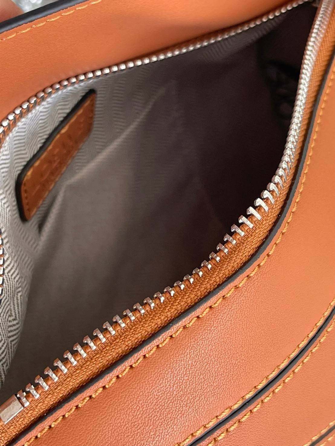 Loewe Puzzle Bag In Classic กระเป๋าทรง Puzzle นี้ออกแบบโดย Jonathan Anderson โดยได้รับแรงบันดาลใจในการออกแบบมาจากรูปทรงของลูกรักบี้ ดังนั้น จึงจะเห็นได้ว่าการตัดเย็บและรูปทรงของกระเป๋านั้นคล้ายคลึงกับลูกรักบี้ รูปทรงดูมินิมอลไม่ทิ้งคอนเซ็ปต์ของแบรนด์ สามา