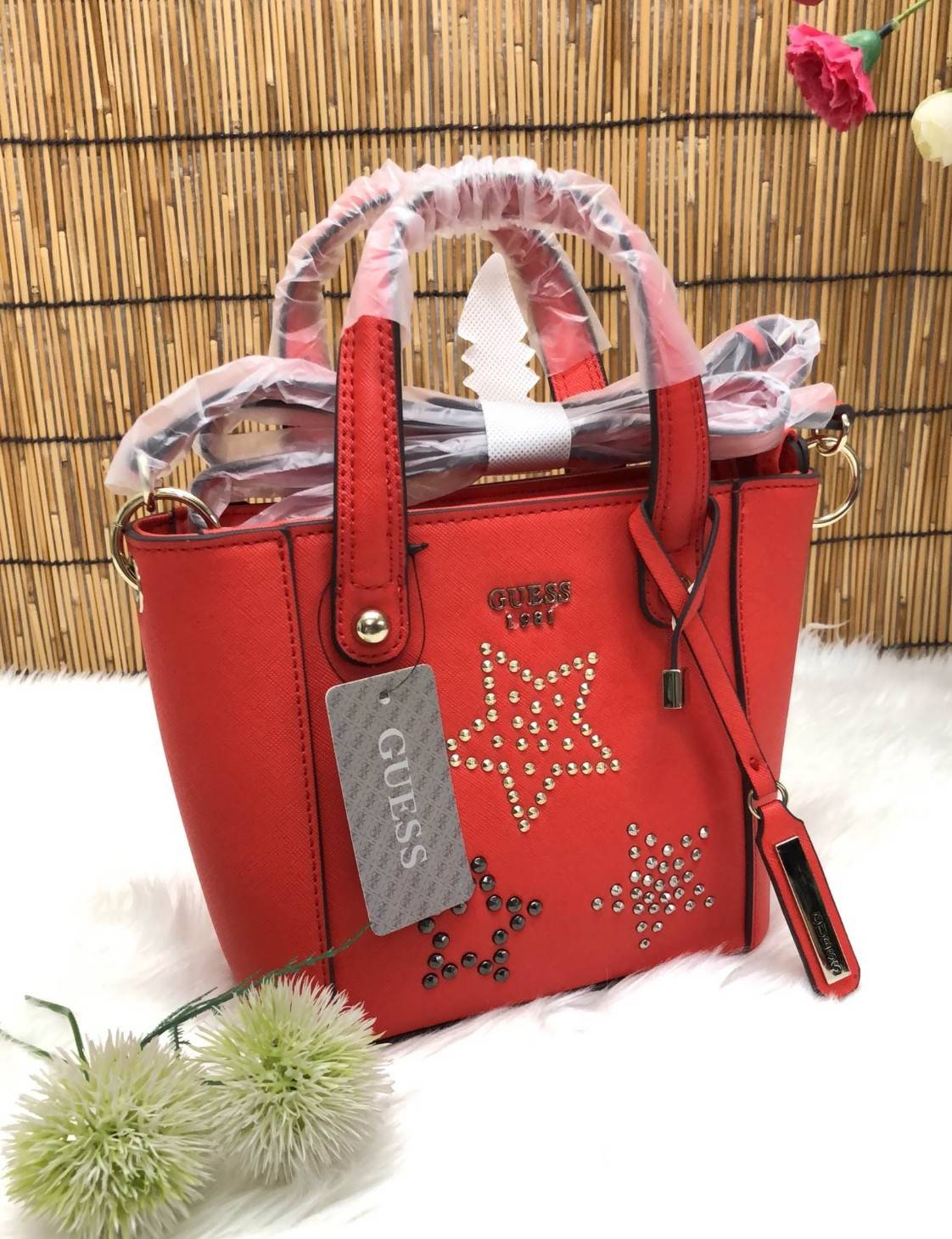 GUESS DELANEY MINI CROSSBODY BAG กระเป๋าถือหรือสะพายข้างได้ วัสดุหนังลาย saffiano ด้านหน้ามีโลโก้แบรนด์ พร้อมตกแต่งรูปดาว และ tag brand ห้อยที่หูกระเป๋า ตัวกระเป๋าเปิดแบบซิป ภายในโล่ง จุได้พอประมาณค่ะ มีช่องซิปอและช่องเล็ก มาพร้อม สายยาวปรับระดับได้ ราคาส