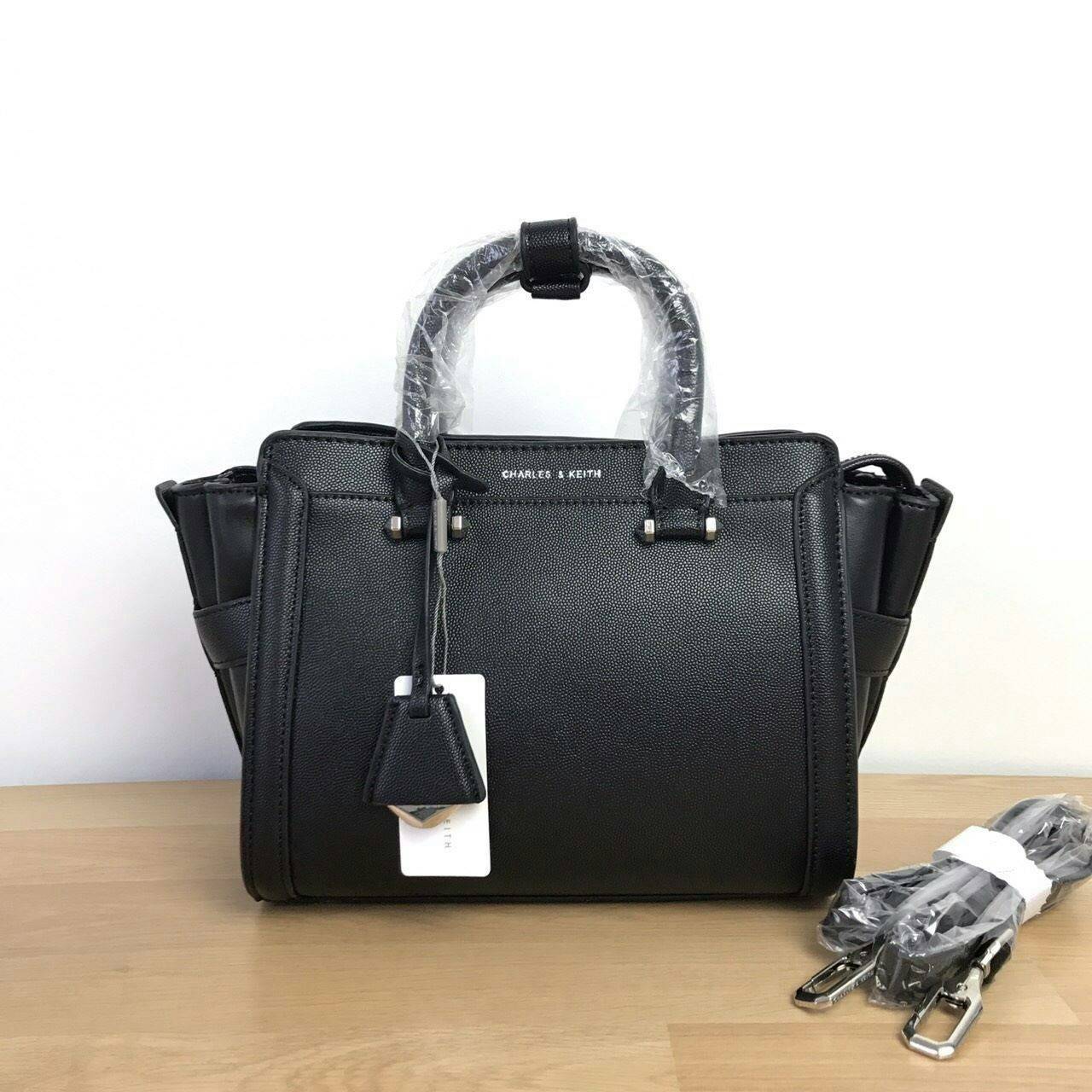CHARLES & KEITH TRAPEZE BAG Best sellwr ! กระเป๋าถือหรือสะพายรุ่นยอดนิยมดีไซน์สวยหรูวัสดุหนัง คาเวียร์อยู่ทรง ด้านข้างเเต่งหนังช่องตัดดูมีดีเทล ด้านหน้าสกรีนโลโก้ ด้านหลังมีช่องซิป เปิดปิดด้วยซิปหัวซิป ปัํ๊มโลโก้ หูจับเเข็งแรง พับลงได้ พร้อมสายสะพายหนังปร