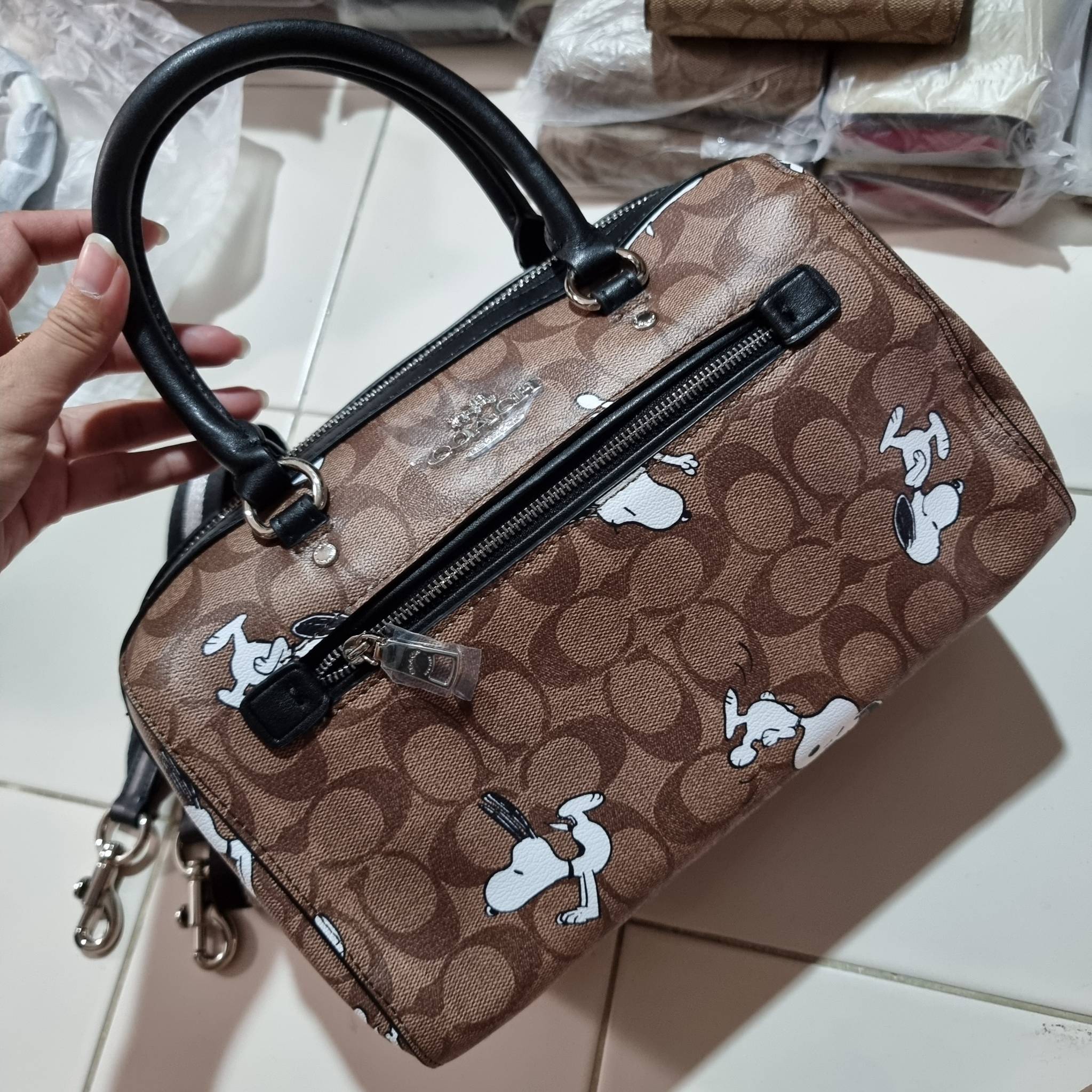 COACH C4118 COACH x PEANUTS ROWAN SATCHEL IN SIGNATURE CANVAS WITH SNOPPY PRINT สนูปพีที่สุดของคอลเลคชั่นแห่งความน่ารัก มาในดีไซน์ของกระเป๋าทรงหมอนยอดฮิต คลาสสิคใช้งานได้ไม่มีเบื่อ รอบนี้มาให้พร้อมสายสะพาย crossbody แบบสปอร์ต ทำให้ใช้งานได้อย่างกระฉับกระเ