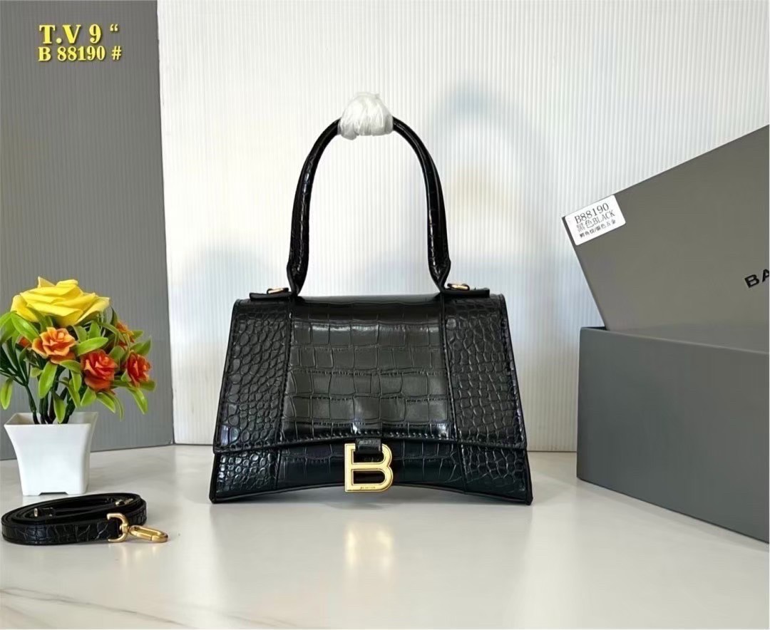 BALENCIAGA Hourglass top-handle tote bag กระเป๋าสะพายแบรนด์หรูซิกเนเจอร์ ที่มาพร้อมดีไซน์โดดเด่น มีความโฉบเฉี่ยว โค้งมนเหมือนพระจันทร์เสี้ยว เพิ่มความสวยสะดุดตาด้วยการตกแต่งอักษร B เมทัลลิก