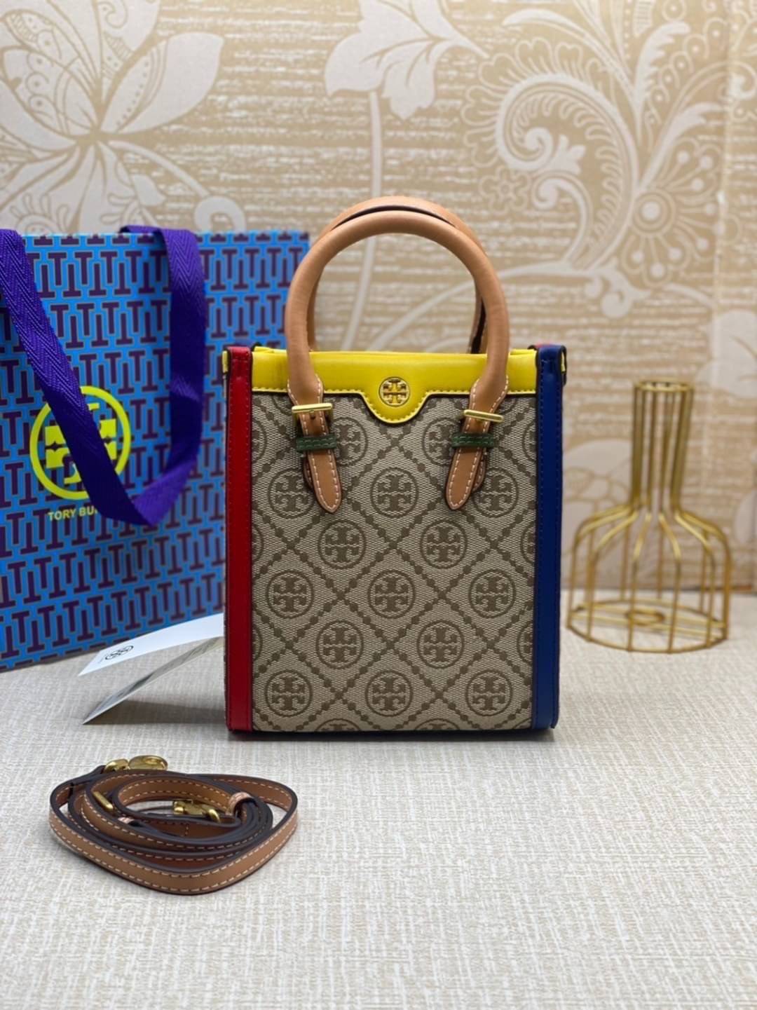 TORY BURCH T MONOGRAM COLORBlOCK JACQUARD MINI TOTE คอลเลคชั่นใหม่ล่าสุด ครอบครองก่อนใคร ไอเท็มยุคนี้รุ่นที่ควรมีติดตู้คะสาวๆ วัสดุ jacquard สลับหนังแท้ หูจับ มาพร้อมสายสะพายข้างหนังแท้ ปรับระดับได้ สายสามารถถอดออกได้ ภายในเป็นช่องโล่ง ใส่มือถือได้ กระเป๋
