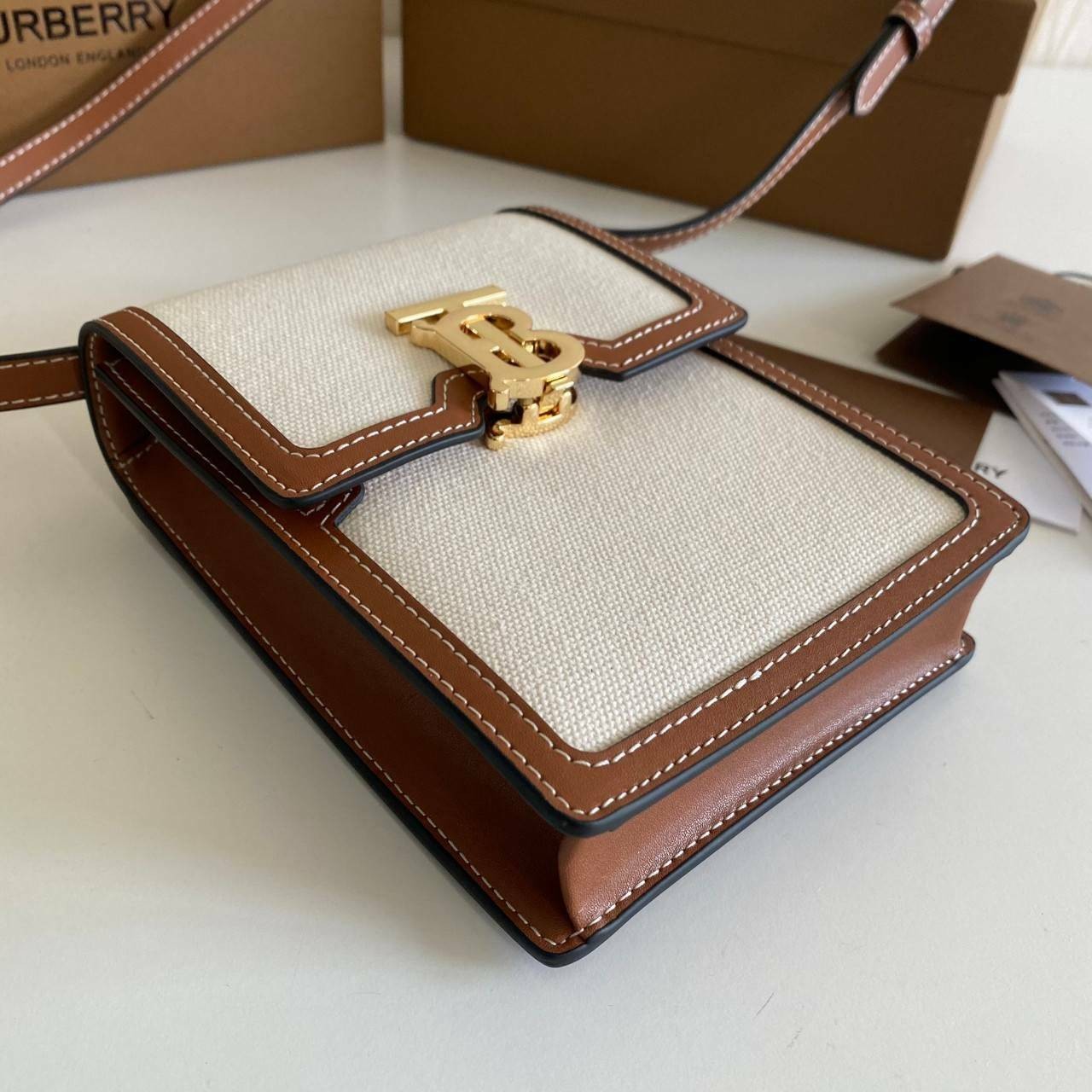 หนังแท้ BURBERRY FRAGRANCES CROSSBODY BAG / Burberry crossbody mini bag Original กระเป๋าสะพายขนาดมินิน่ารัก ใช้งานง่าย งานหนังแท้ & Canvas Cotton เกรดออริจินอล ทรงเหลี่ยมแนวตั้งดีไซน์สวยหรูอยู่ทรงมีโลโก้แบรนด์ด้านหน้า เปิดปิดด้วยฝาปิดสัญลักษณ์รูปตัวB ภายใ