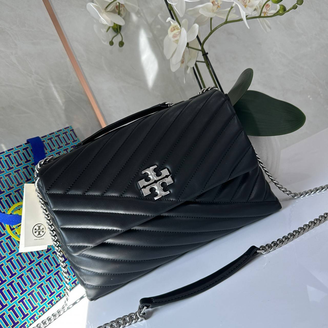 TORY BURCH KIRA CHEVRON CONVERTIBLE SHOULDER BAG กระเป๋าสะพายไซส์ใหญ่ หรูหราสุดคลาสสิก วัสดุหนังแกะทั้งใบ เปิด-ปิดด้วยกระดุมแม่เหล็ก ภายในเป็นช่องโล่ง ใส่ของสำคัญได้ครบ สายสะพายในตัวปรับได้ 2 แบบ สะพายไหล่โซ่คู่หรือจะ ครอสบอดี้ก็เริ่ดคะ