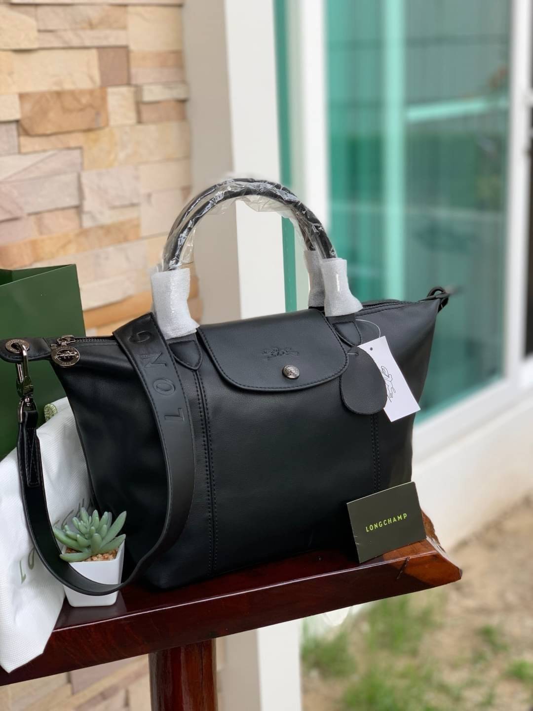 Longchamp LE PLIAGE CUIR TOP HANDLE BAG S เรียกว่าเป็นกระเป๋าอีกหนึ่งรุ่นที่ไม่ว่ายังไงก็ฮอตฮิตและติดเทรนด์ตลอดไม่เคยเปลี่ยนกับ ทรง Le Pliage Cuir หนึ่งในตระกูลกระเป๋าสุดไอคอนิกจากแบรนด์ เมื่อรุ่น Le Pliage Cuir ในรูปแบบของหนังแกะ Metis ได้ถือกำเนิดขึ้นใน