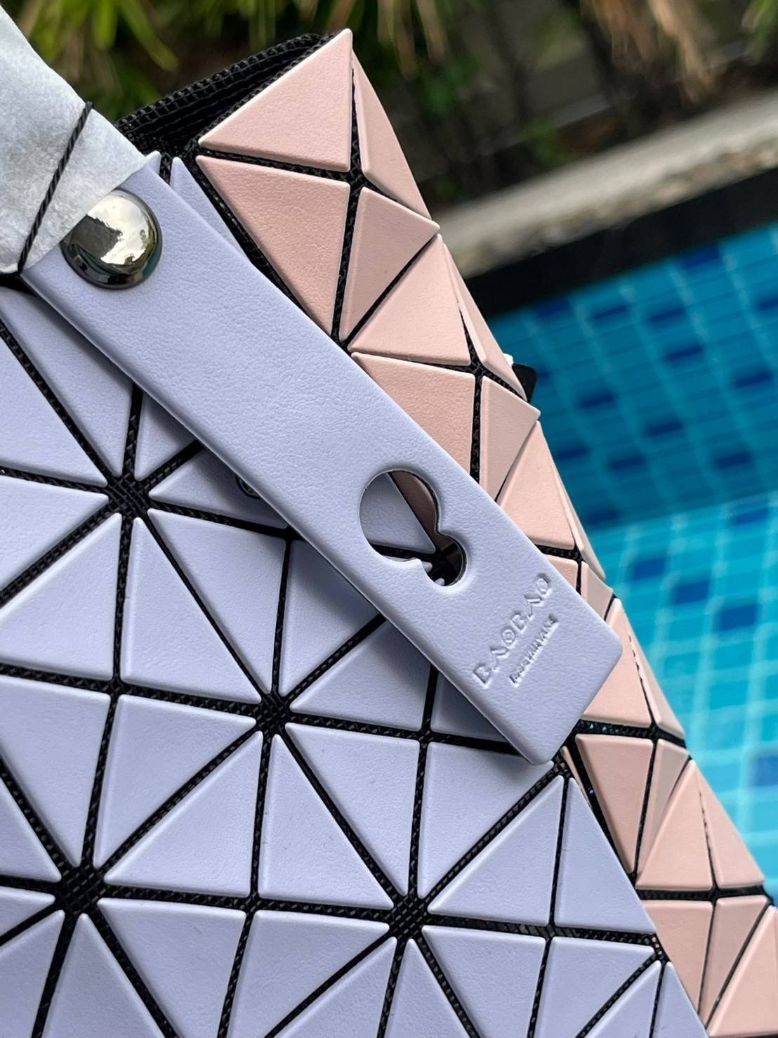 Baobao Issey Miyake Prism Kangaroo tote bag กระเป๋าถือทรงโท้ทที่ประดิษฐ์ขึ้นอย่างเชี่ยวชาญในญี่ปุ่น มาพร้อมแผงเรขาคณิตสำหรับการออกแบบที่ได้รับแรงบันดาลใจจากกระดาษพับ ซิลลูเอทอันเป็นเอกลักษณ์นี้ปิดท้ายด้วยสายรัดแบบอสมมาตร มีการพัฒนาโครงสร้างทรงสามเหลี่ยมเพ