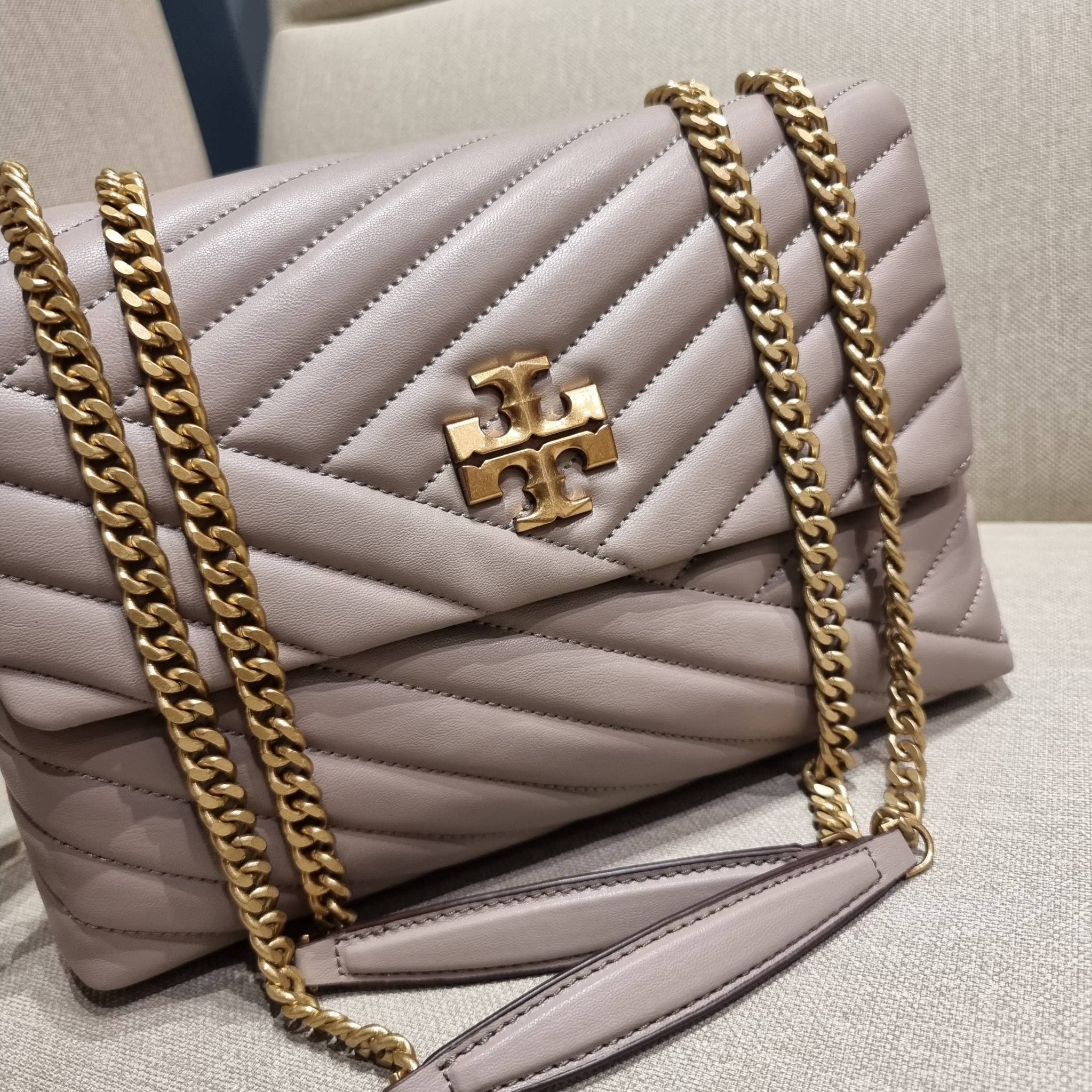 TORY BURCH KIRA CHEVRON CONVERTIBLE SHOULDER BAG กระเป๋าสะพายรุ่นยอดฮิต ไซส์ใหญ่จัดเต็มให้เน้นๆ ใช้ยังไงก็ดูหรู ดีไซน์เฉพาะตัว วัสดุหนังแกะ สัมผัสนิ่ม เปิด-ปิดด้วยกระดุมแม่เหล็ก ภายในเป็นช่องโล่ง แบ่งสัดส่วนไว้ดีมากๆ ใส่กระเป๋าสตางค์ มือถือ เครื่องสำอางค์