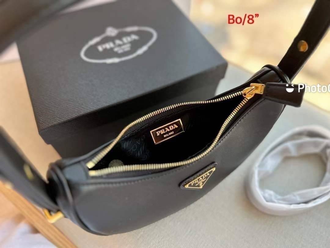 PRADA HOBO LEATHER SHOULDER BAG ฮอตไอเท็ม กระเป๋าถือ/สะพาย ทรงโฮโบ สวยผู้ดี ใช้งานง่าย โดดเด่นด้วยโลโก้สีทอง เปิด-ปิดด้วยซิป มีหูหิ้วในตัว ภายในเป็นช่องโล่ง ใส่ของสำคัญได้สบายๆ บอกเลยห้ามพลาดจ้า