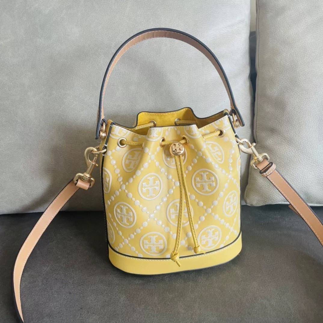 Medium : Tory Burch T Monogram Embossed Bucket Bag กระเป๋าถือหรือสะพายไหล่ ประดับด้วยลวดลายอันเป็นสัญลักษณ์ของแบรนด์ ถูกประดิษขึ้นด้วยความพิถีพิถันวัสดุหนังอย่างดี ด้านในบุด้วยหนังไมโครซูแอคเนื้อนุ่มทำความสะอาดง่าย กระเป๋าผ่าหลังด้านนอก1ช่อง ด้านใน 1ช่อง 