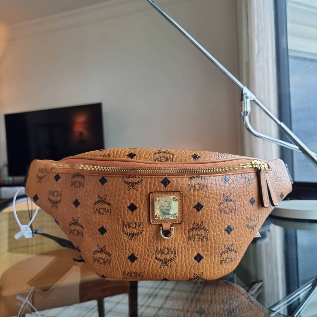 M.C.M FURSTEN BELT BAG IN VISETOS กระเป๋าคาดอกยอดฮิต หนุ่มๆสาวๆใช้ได้ไม่มีเบื่อ รุ่นขายดี ลายวิเซโต้เอกลักษณ์ ทั้งสปอร์ตและดูหรูในตัว ใช้งานง่าย ได้ทุกลุค วัสดุหนังแคนวาสคุณภาพดี มีช่องซิปหลัก และซิปด้านหลังกระเป๋า ภายในเป็นช่องโล่งบุผ้าซับอย่างดี รุ่น un
