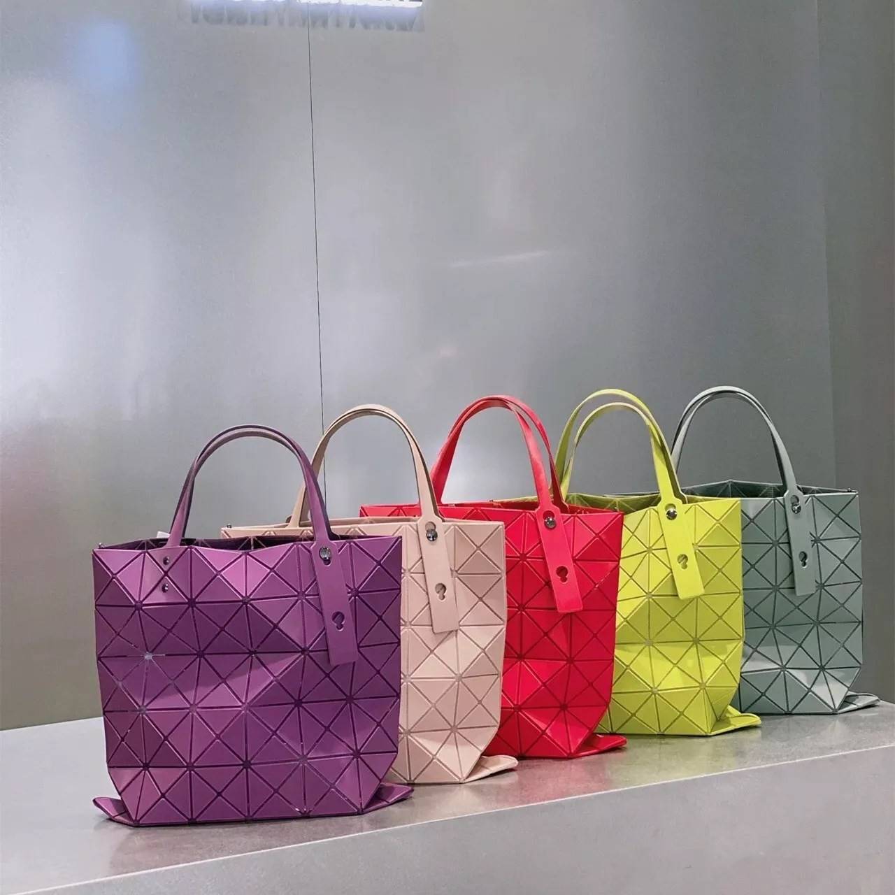 BAO BAO ISSEY MIYAKE LUCENT ONE-TONE กระเป๋าสะพายไหล่ ทรงโท้ท ใบใหญ่สวยมาก ปรับได้หลายทรงตามเอกลักษณ์เฉพาะของแบรนด์นี้ วัสดุ 100% POLYESTER PARTLY: SYMYHETIC LEATHER ด้านในใส่ของได้เยอะมาก ใส่ไอแพด สมุดโน้ตได้สบายเลย วัยทำงานหรือวัยนักศึกษา อย่างน้อยต้องม
