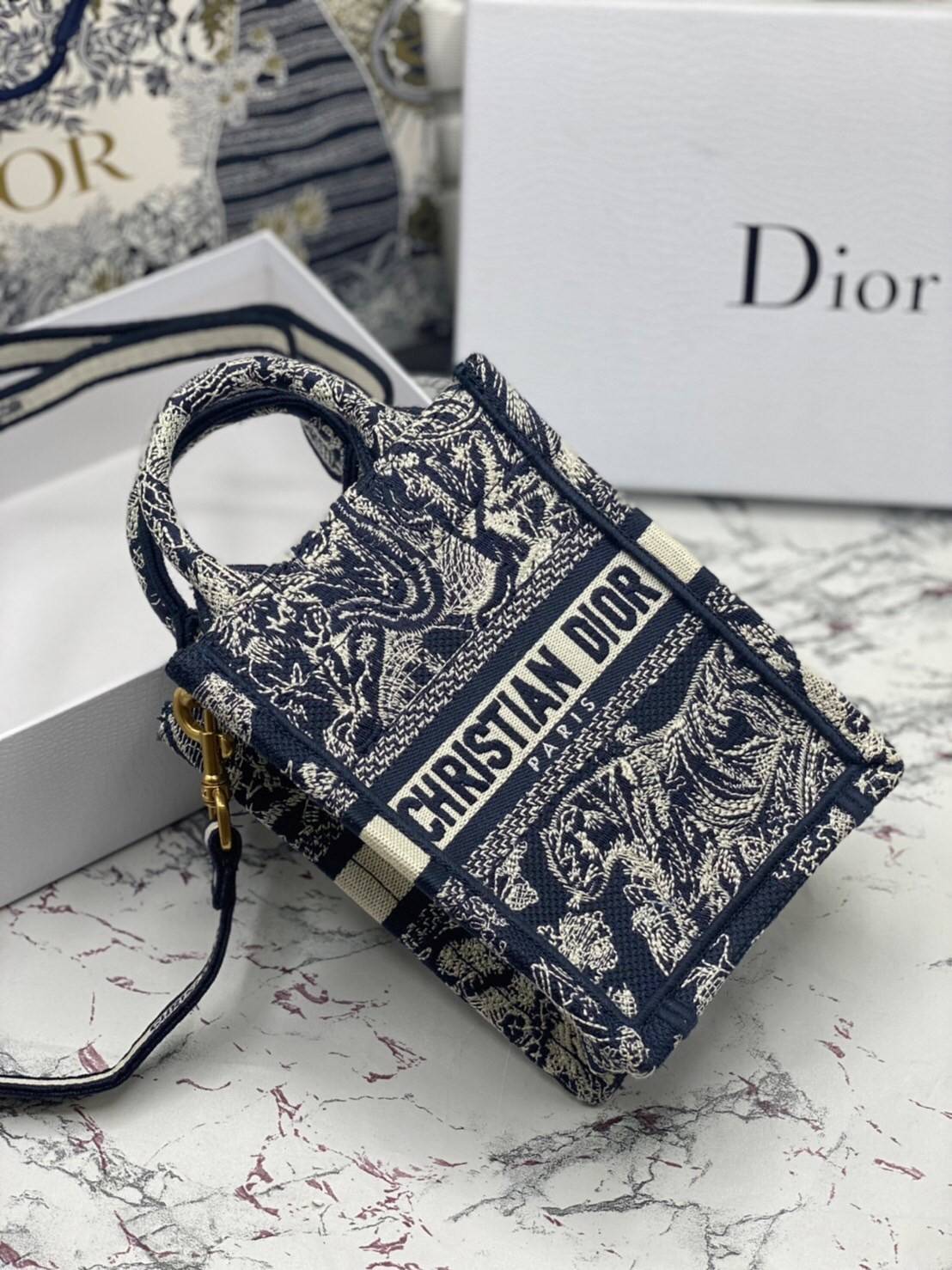 ORI 】Mini Dior Book Tote Phone Bag พร้อมส่งที่ไทย ภาพสินค้าถ่ายจากงานขายจริง ใช้งานต่างประเทศได้ กระเป๋าใบมินิจะใส่โทรศัพท์ได้เช่นเดียวกับของใช้จำเป็นเล็กๆ น้อยๆ ในแต่ละวัน มาพร้อมสายสะพายไหล่แบบปักที่ปรับได้และถอดออกได้ อุปกรณ์เสริมอันทันสมัยนี้สามารถสวม