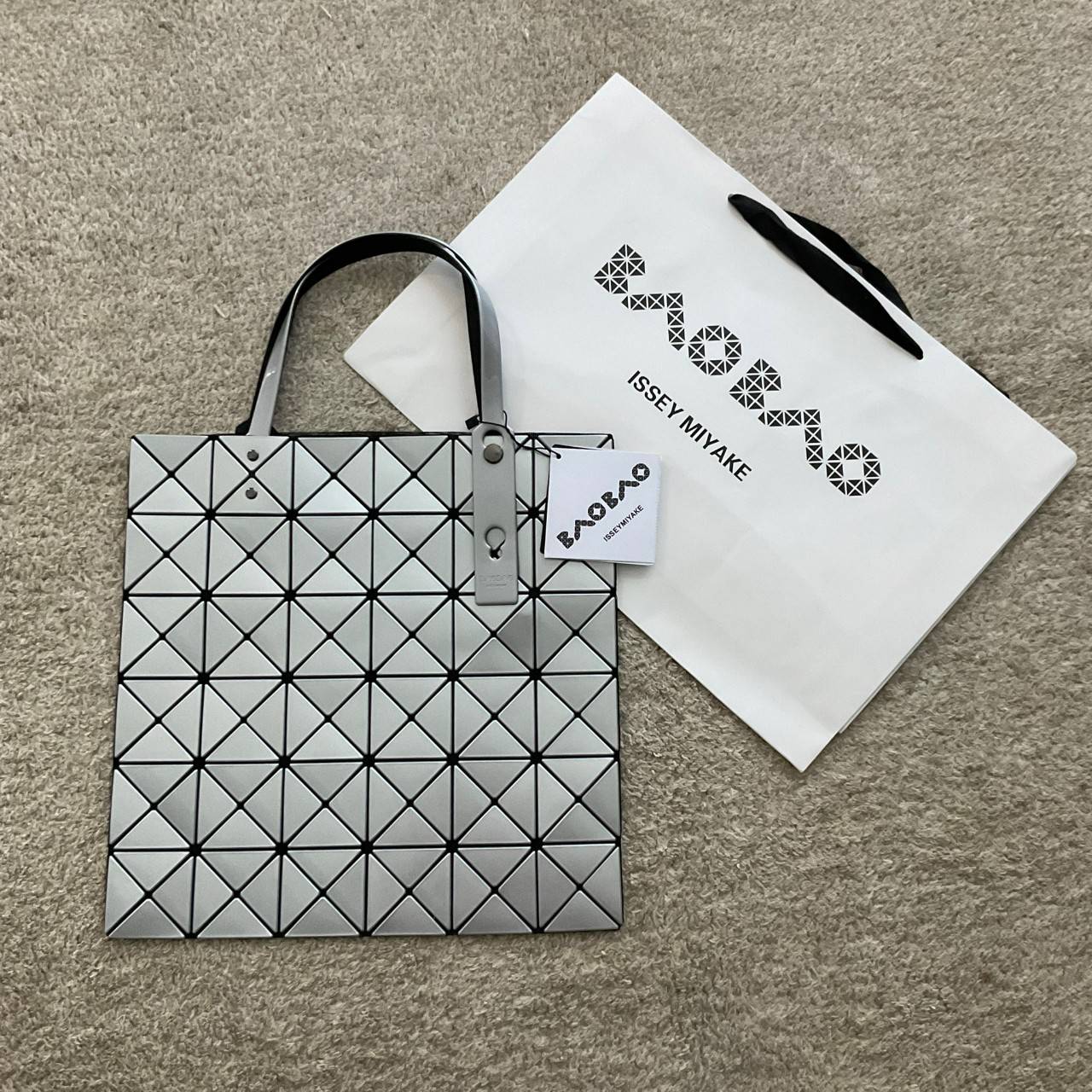 BAO BAO ISSEY MIYAKE TOTE BAG (6x6) กระเป๋าสะพายไหล่ ใบใหญ่ ทรงโท้ท จุดเด่นคือ ปรับได้หลายทรงตามเอกลักษณ์เฉพาะของแบรนด์นี้ ด้านในใส่ของได้เยอะมาก ใส่ไอแพด สมุดโน้ตได้สบายเลย พร้อมช่องซิปใส่ของให้อีกหนึ่งช่อง วัยทำงานหรือวัยนักศึกษา อย่างน้อยต้องมีแบรนด์นี