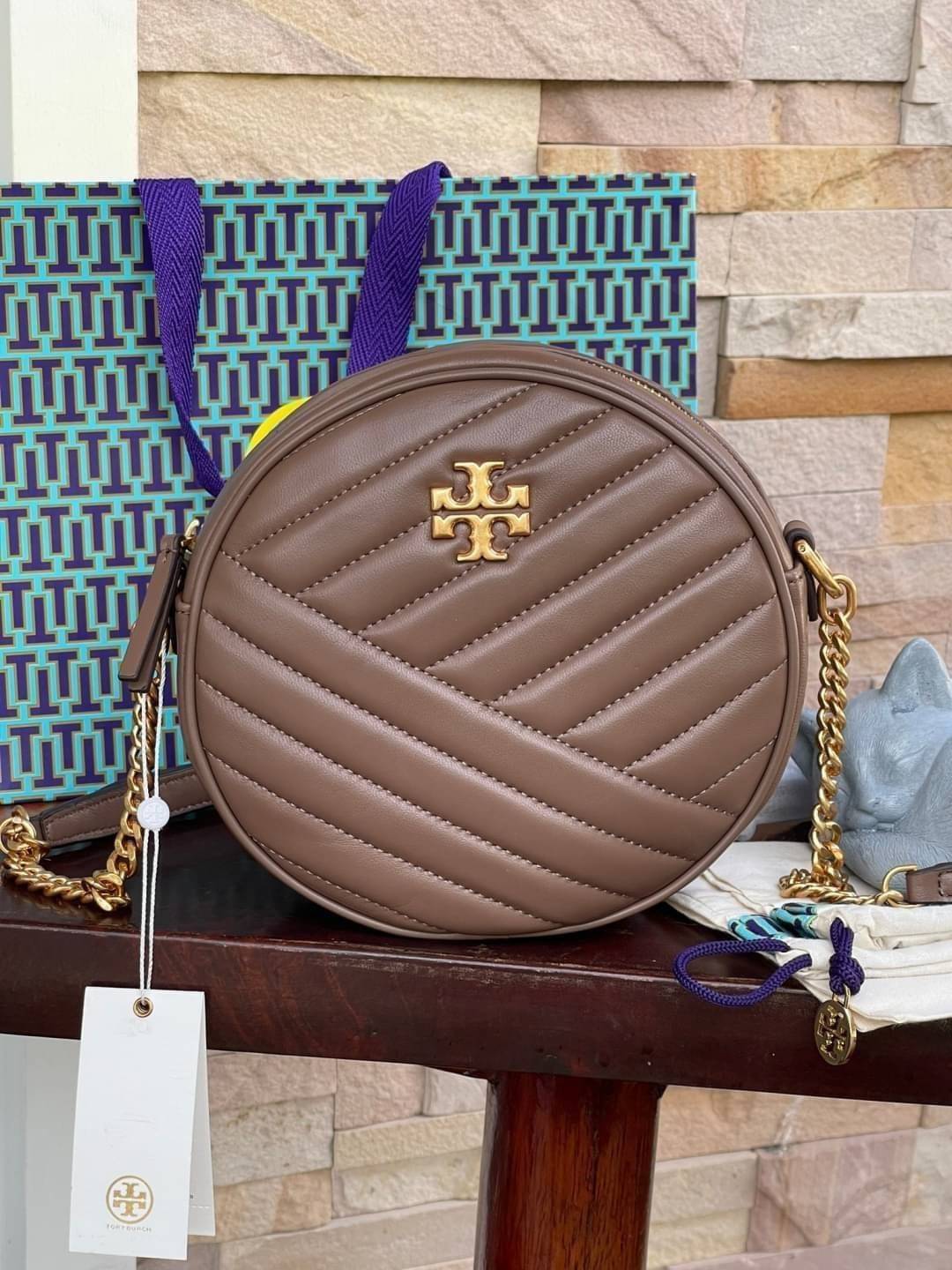 Tory burch Kira Cheron Circle Crossbody กระเป๋าสะพายคาดลำตัวรุ่นนี้โดดเด่นด้วยรูปทรงกลมสุดชิค ขนาดกะทัดรัด พร้อมด้วยหนังกระเป๋าที่ทำจากหนังแท้คุณภาพดี เพราะ Kira Chevron เป็นรุ่นที่ตอบโจทย์และครองใจสาว ๆ ได้อย่างแท้จริง เนื่องจากมีดีไซน์เรียบหรู โดยทางแบร