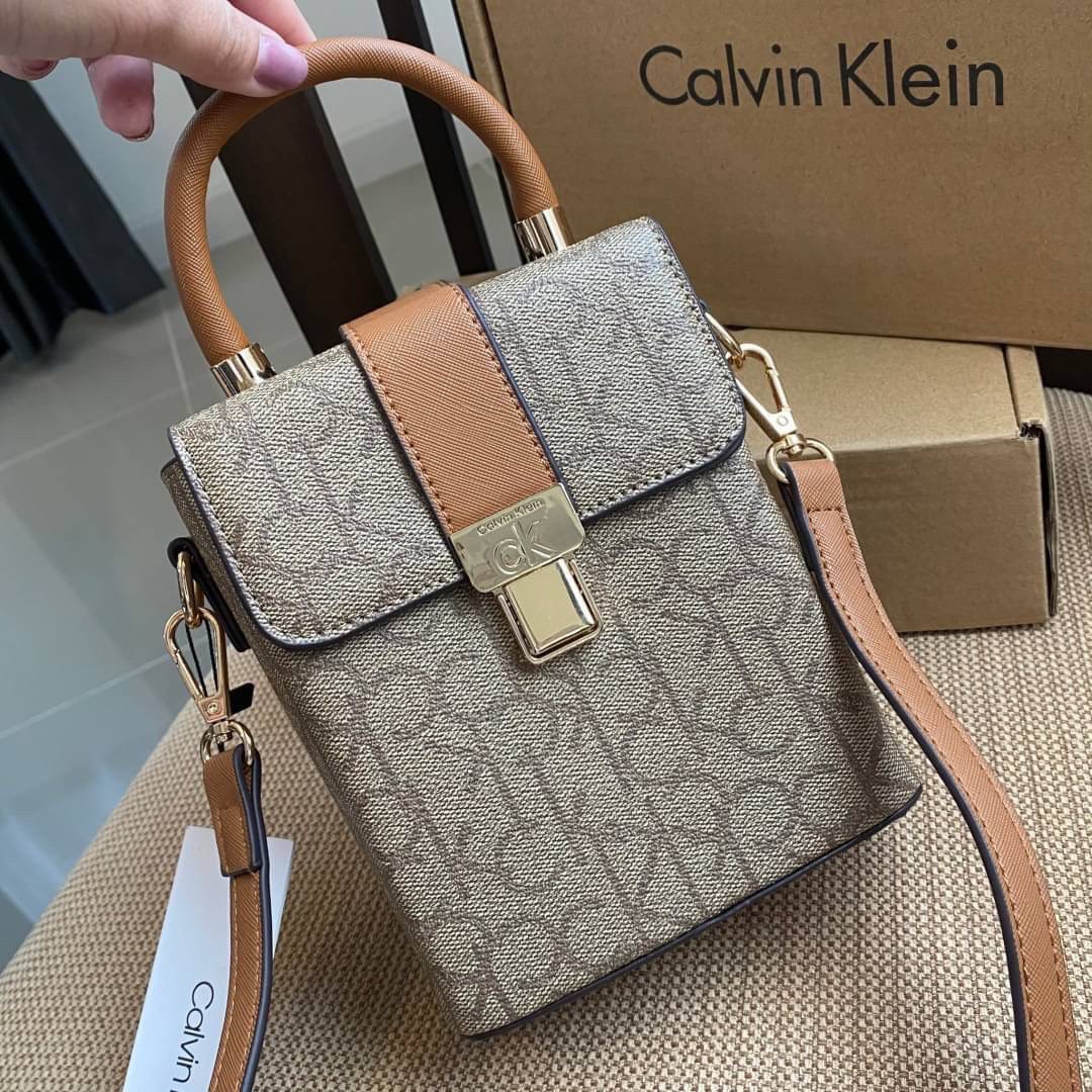 CALVIN KLEIN JEANS crossbody bag กระเป๋าถือหรือสะพาย ลายซิกเนเจอร์แบรนด์ทั้งใบ มีหูจับสำหรับถือ เปิด-ปิดกระเป๋าด้วยกระดุมแม่เหล็ก ด้านในโล่งกว้างมีช่องเล็กและช่องซิปสำหรับใส่ของจุกจิก ซับในลายแบรนด์อย่างดี มาพร้อมสายสะพายยาวปรับระดับได้ สามารถใช้ได้หลากหล