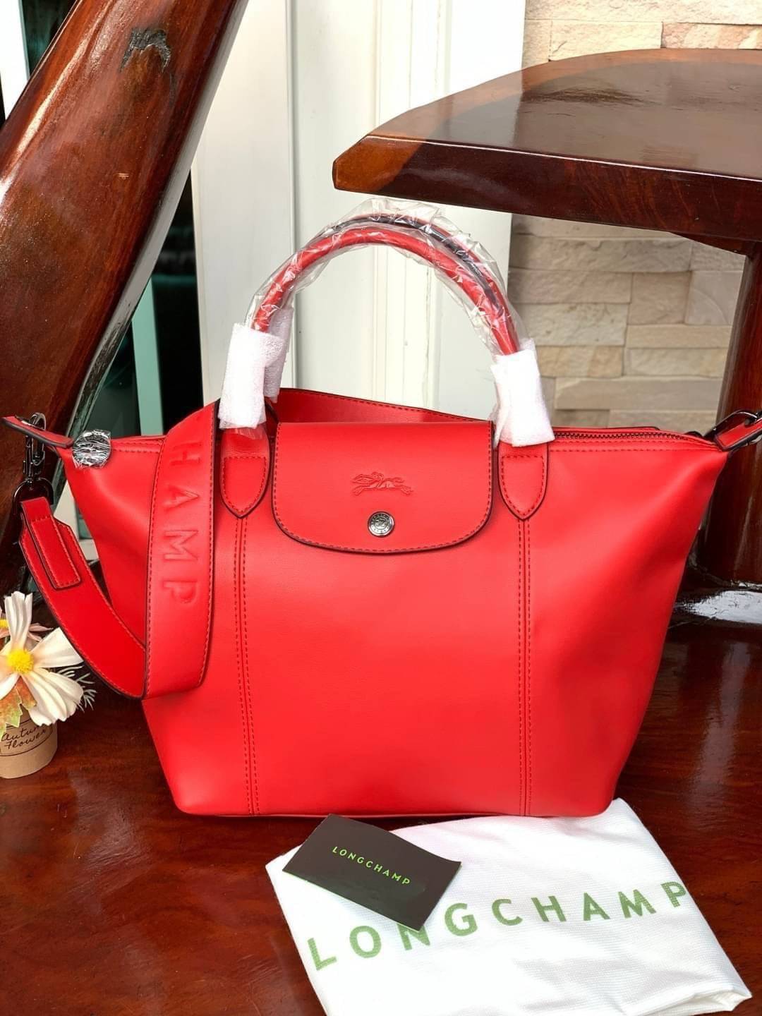 Longchamp LE PLIAGE CUIR TOP HANDLE BAG S เรียกว่าเป็นกระเป๋าอีกหนึ่งรุ่นที่ไม่ว่ายังไงก็ฮอตฮิตและติดเทรนด์ตลอดไม่เคยเปลี่ยนกับ ทรง Le Pliage Cuir หนึ่งในตระกูลกระเป๋าสุดไอคอนิกจากแบรนด์ เมื่อรุ่น Le Pliage Cuir ในรูปแบบของหนังแกะ Metis ได้ถือกำเนิดขึ้นใน