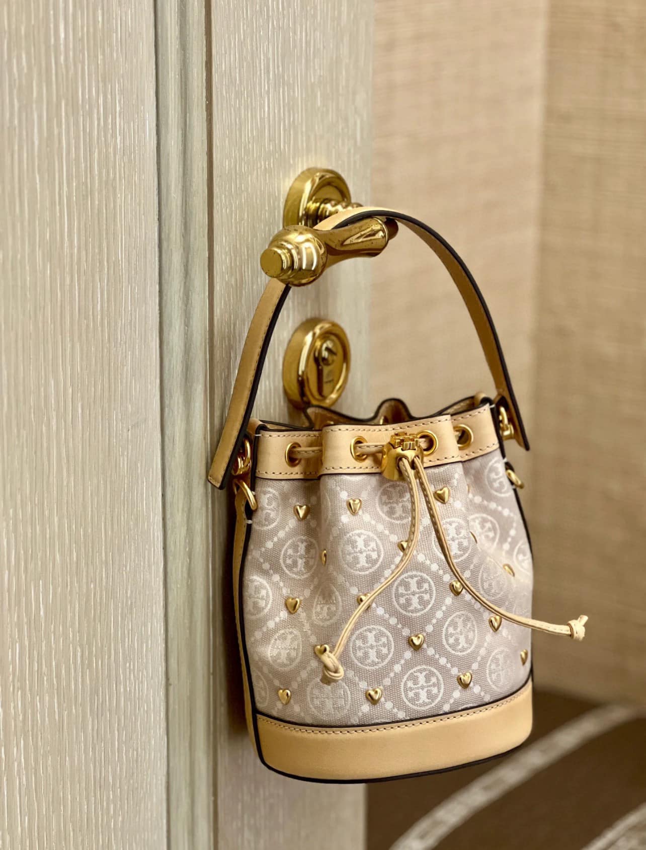 TORY BURCH T MONOGRAM EMBELLISHED MINI BUCKET BAG NEW IVORY MULTI กระเป๋าทรงบัคเก็ตแต่งหัวใจสีทองสวยหรู น่ารักรุ่นใหม่ล่าสุด เกรดท็อปออริ เทียบแท้ 1:1 เกรดดีสุด ใช้งานต่างประเทศได้