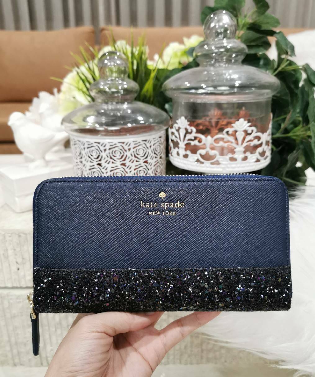 KATE SPADE NEW YORK GLITTER LONG WALLET กระเป๋าสตางค์ใบยาวรุ่นใหม่ล่าสุดจาก KATE SPADE FACTORY หนัง SAFFIANO ตัด Gitter วิ้งๆสวยหรูอยู่ทรงตามคอนเซปคอลเลคชั่นใหม่ เปิดปิดด้วยซิปรอบด้านหน้ามีโลโก้สวยเรียบหรูภายในมีโลโก้ ช่องซิปกลาง ช่องใส่บัตรหลายช่อง สามาร