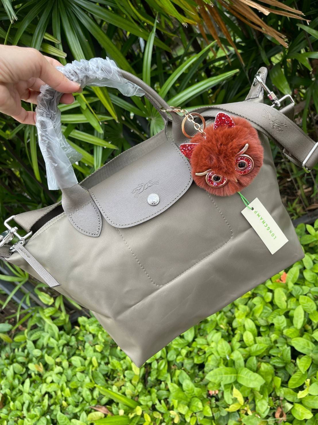 Longchamp LE PLIAGE NÉO TOP HANDLE BAG อีกหนึ่งรุ่นยอดนิยม ที่สาวๆ ต้องมีไว้เก็บไว้สักใบ กระเป๋าโท้ทใบนี้ มาพร้อมกับสีที่มีสไตล์เรียบง่าย มีสายสะพายยาวปรับสั้นยาวได้ช่วยให้คุณสามารถสะพายไหล่ได้อย่างสบาย ในตัวสายปักโลโก้อันเป็นสัญลักษณ์ ในขณะที่ที่ปิดแบบซิ