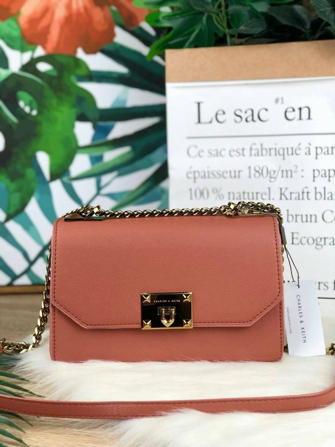 CHARLES & KEITH METAL PUSH LOCK CROSSBODY BAG รุ่นฮิตขายดีมีมาพร้อมส่งแล้วจ้า กับกระเ๋าสะพายไซส์น่ารัก วางอยู่ทรง เปิดปิดด้วย ตัวล็อกด้านหน้า ด้านในแบ่งเป็น 2 ช่องมีช่องซิปตรงกลาง จุของได้เยอะพอควรเลยค่ะ ใส่ iPhone plus ได้สบายๆ และของจุกจิกที่จำเป็น รุ่น