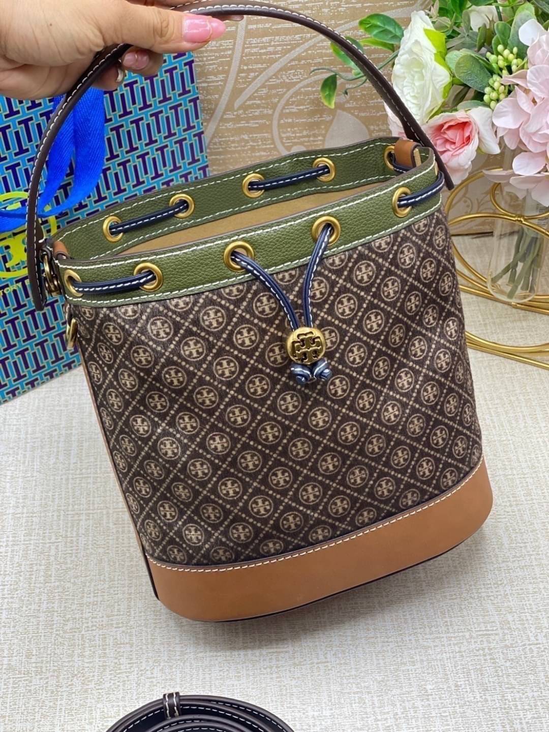 TORY BURCH T Monogram Calf Hair Bucket Bag MEDIUM ไอเท็มใหม่ที่ใครๆก็รอ กระเป๋าบัคเก็ตทรงสวย ที่ยังคงให้ความโดดเด่นด้วยลวดลายเอกลักษณ์ เพิ่มเติมดีไซน์บล็อคสี ตัดกันได้อย่างลงตัว