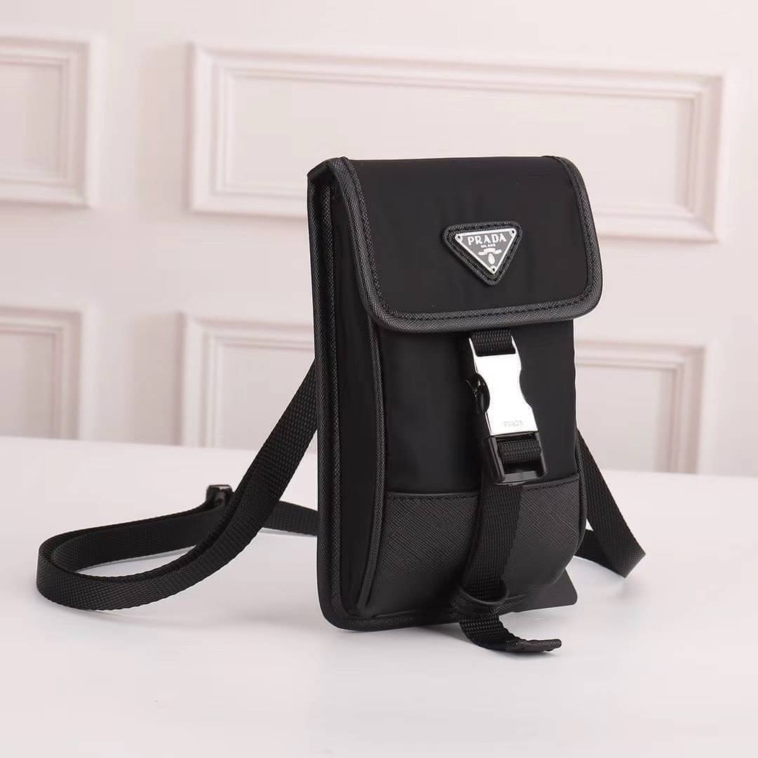 VIP Prada crossbody nylon bag PRADA Re-Nylon and Saffiano leather smartphone case เป็นรุ่นที่ถามหากันเยอะมากๆ งานสวยมาก ทำจากผ้าnylonพิเศษ กันน้ำได้ระดับนึงเลยค่ะ สลับหนังแท้ ใช้ได้ทั้งชาย-หญิง จะ Cross body คาดเอว หรือคล้องกับหูกางเกงชิคๆ ก็เท่มากเลยค่าา