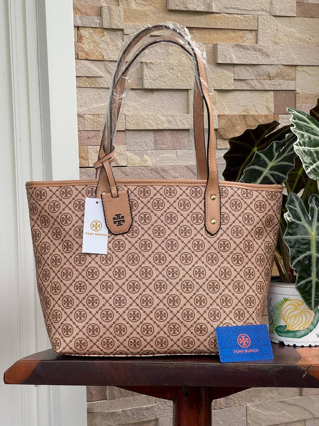 OUTLET 】Tory burch T Monograme Large shopping bag กระเป๋าสะพายใบไหล่ใบใหญ่ โดยตัวกระเป๋าทำมาจากผ้าแคนวาสเคลือบผิวด้านทนต่อรอยขีดข่วนได้เป็นอย่างดี ขนาดที่ใหญ่สามารถใส่ได้ทั้งเอกสารและสัมภาระต่างๆ พร้อมด้วยซิปปิดกระเป๋าด้านบนจึงเป็นอีกรุ่นที่เหมาะกับสาวออฟ