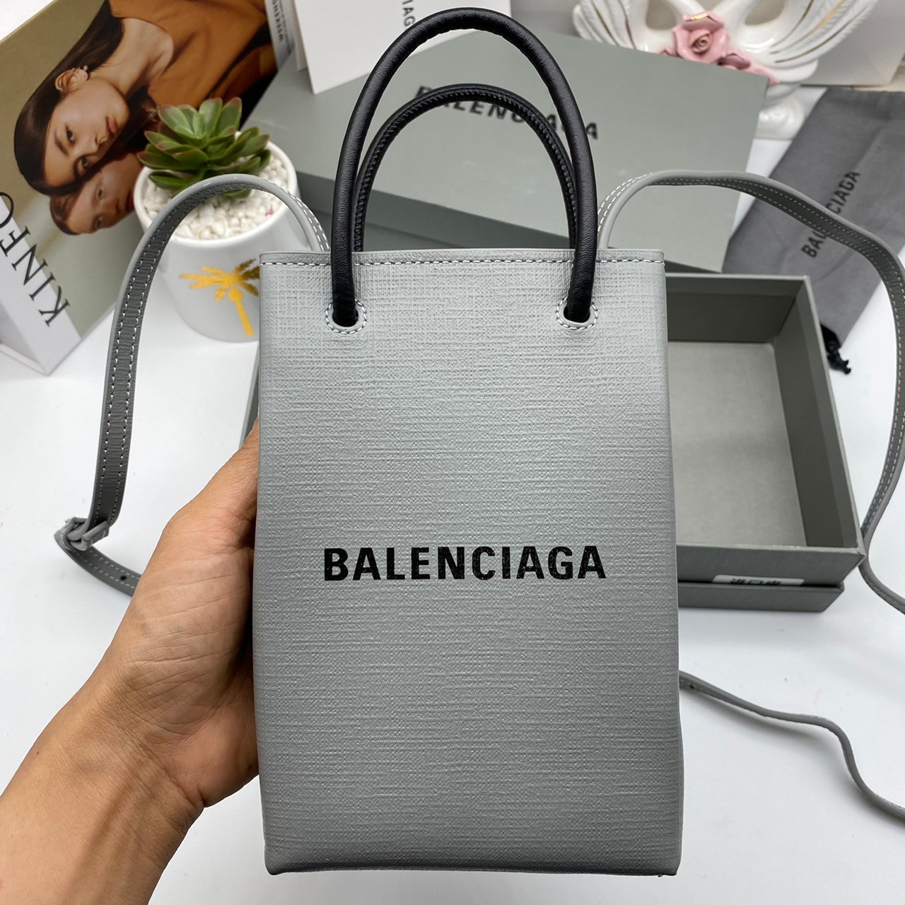 หนังแท้ BALENCIAGA Shopping Phone Pouch leather tote พกกระเป๋าช้อปปิ้งขนาดมินิ ไปทุกที่ในฤดูกาลนี้ ดีไซน์ที่ใช้ได้ทุกวันตั้งแต่หนังแบบมีเท็กซ์เจอร์ ภาพสินค้าถ่ายจากงานขายจริง ใช้งานต่างประเทศได้