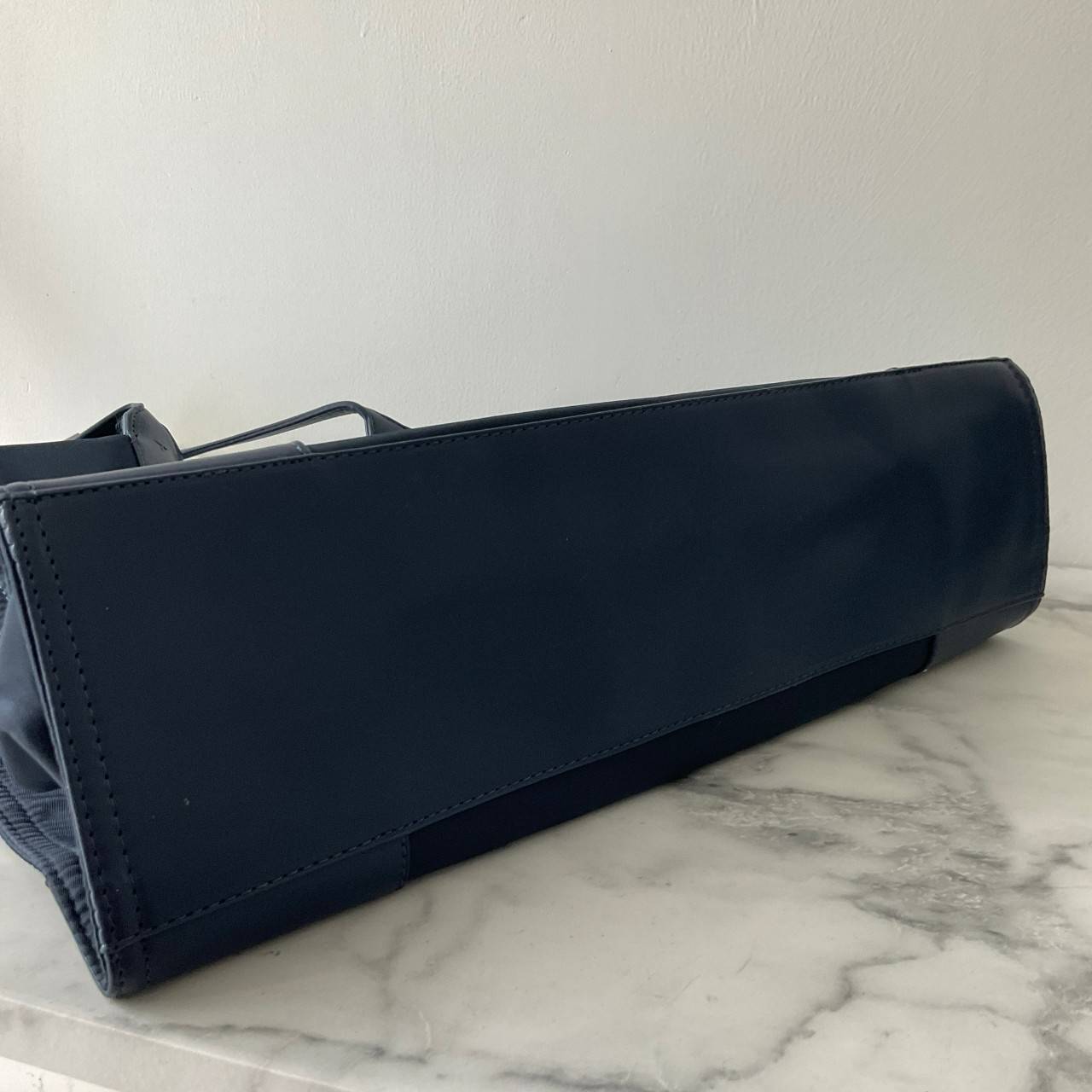 กระเป๋าทรงโท้ทใบใหญ่ TORY BURCH ELLA TOTE BAG วัสดุ NYLON ทั้งใบตัดด้วยหนังสีดำ แต่งโลโก้แบรนด์ด้านหน้า ด้านข้างมีกระดุม สามารถขยายทรงได้ ด้านในเปิดปิดด้วยกระดุมแม่เหล็กฝัง ช่องกว้างหลักหนึ่งช่องและช่องซิปอีกช่อง สามารถใส่แล็ปท็อปได้สบาย ใบใหญ่เว่อวัง ไอเ