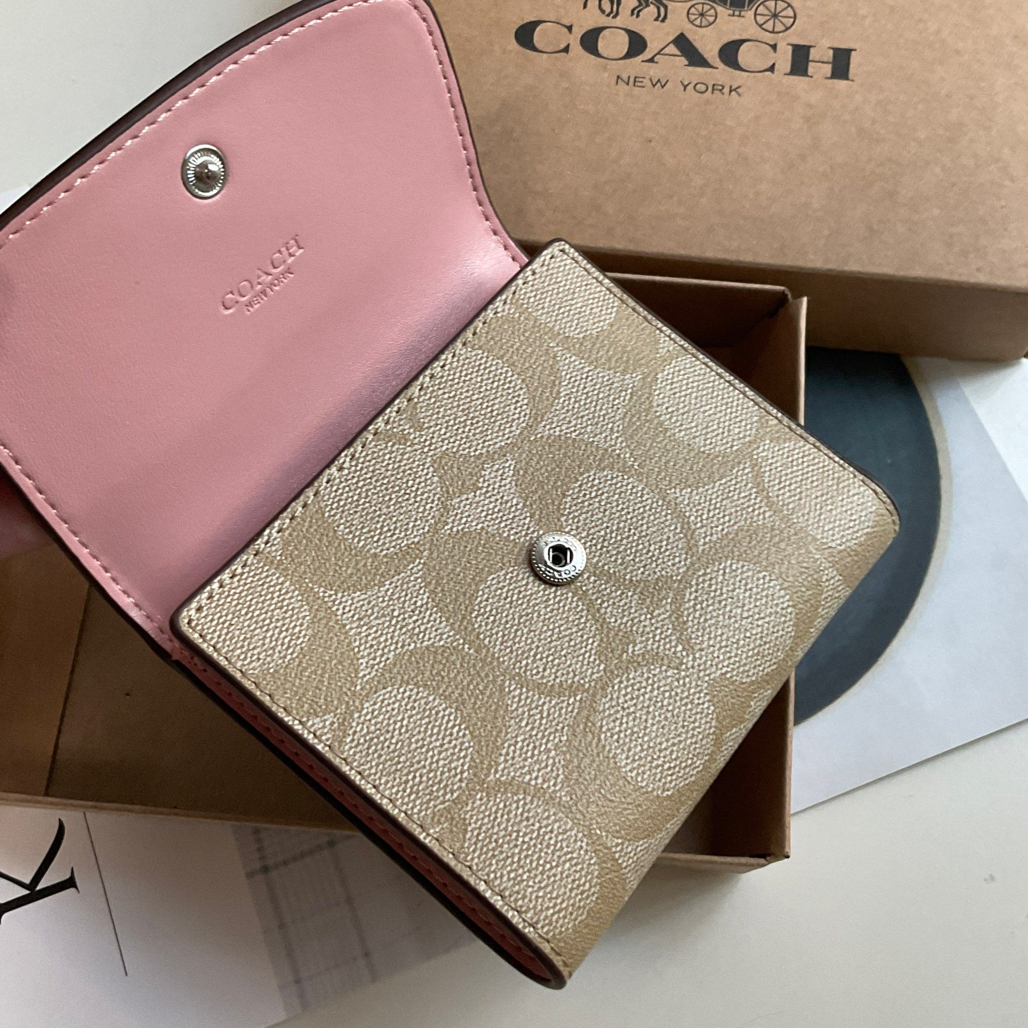 COACH SMALL WALLET IN SIGNATURE CANVAS กระเป๋าสตางค์ใบสั้น แบบพับสามตอน เปิดปิดด้วยกระดุมปั้มแบรนด์ ด้านในมีช่องใส่บัตรหลายช่อง และช่องใส่ธนบัตร ด้านหลังมีช่องซิปเหรียญอีกหนึ่งช่อง น้ำหนักเบา พกพาสะดวก อะไหล่เงาสุดหรู ห้ามพลาดค่ะ!