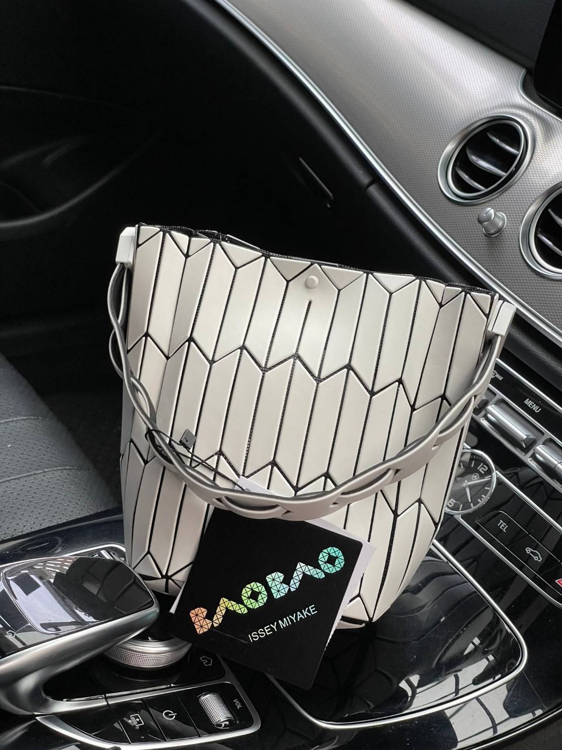 Small : BAO BAO ISSEY MIYAKE SMALL BUCKET เป็นกระเป๋าบัคเก็ตขนาดเล็กสามารถใช้ใส่กระเป๋าสตางค์และโทรศัพท์มือถือได้ ซีรีย์ใหม่นี้มีจุดเด่นที่แผ่นรูปทรงสี่เหลี่ยมด้านขนานในแนวตั้ง เกิดเป็นรูปทรงสามมิติซึ่งแตกต่างไปจากรูปทรงที่เกิดขึ้นจากแผ่นสามเหลี่ยม หูหิ้ว