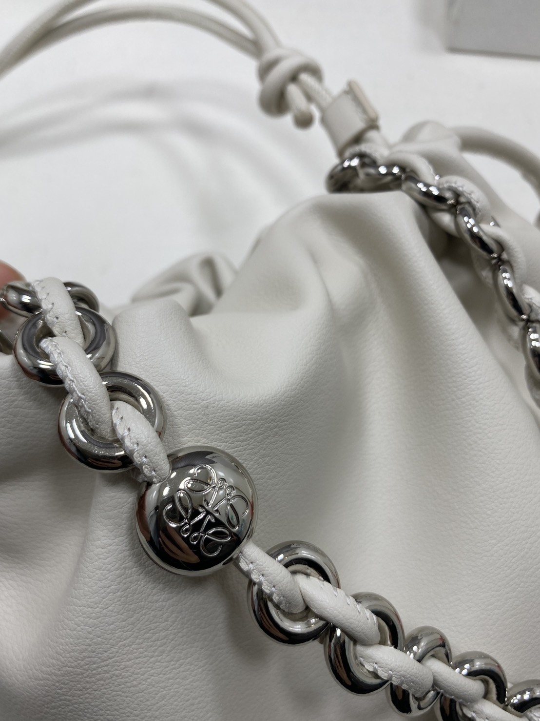 ORI หนังแท้ | LOEWE Mini Flamenco purse in mellow nappa leather / Loewe Bucket Bag กระเป๋าสะพายทรงบัคเก็ตไซส์มินิ หนังเรียบสวยหรู เรียบง่าย หนังแท้ผิวสัมผัสนุ่มมือ น้ำหนักเบาและนุ่มสบาย ดีไซน์จับจีบ เชือกผูกแบบปมโบราณ และสายโซ่รูปโดนัท