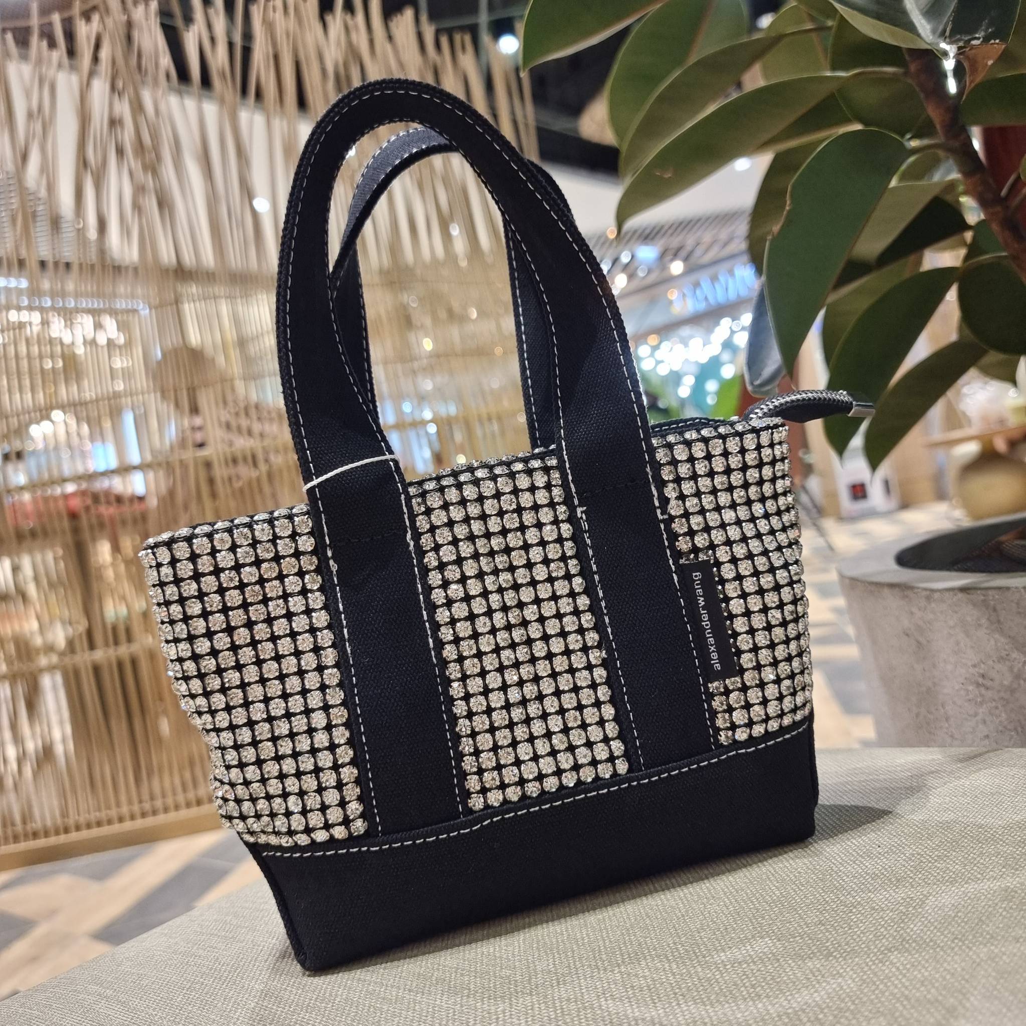 ALEXANDER WANG HANDBAG MINI TOTE WITH RHINESTONE กระเป๋าทรงมินิโท้ท น่ารักน่าเอ็นดู น่าใช้เหลือเกิน!! ด้วยความโดดเด่นเด่นของการตกแต่งพลอยเทียม ให้ดีเทลหรู ตัดสลับด้วยผ้าแคนวาส เพิ่มความทนทาน ลงตัวมากๆ และยังใช้งานง่ายด้วยหูจับในตัว เปิด-ปิดด้วยซิป ภายในเป