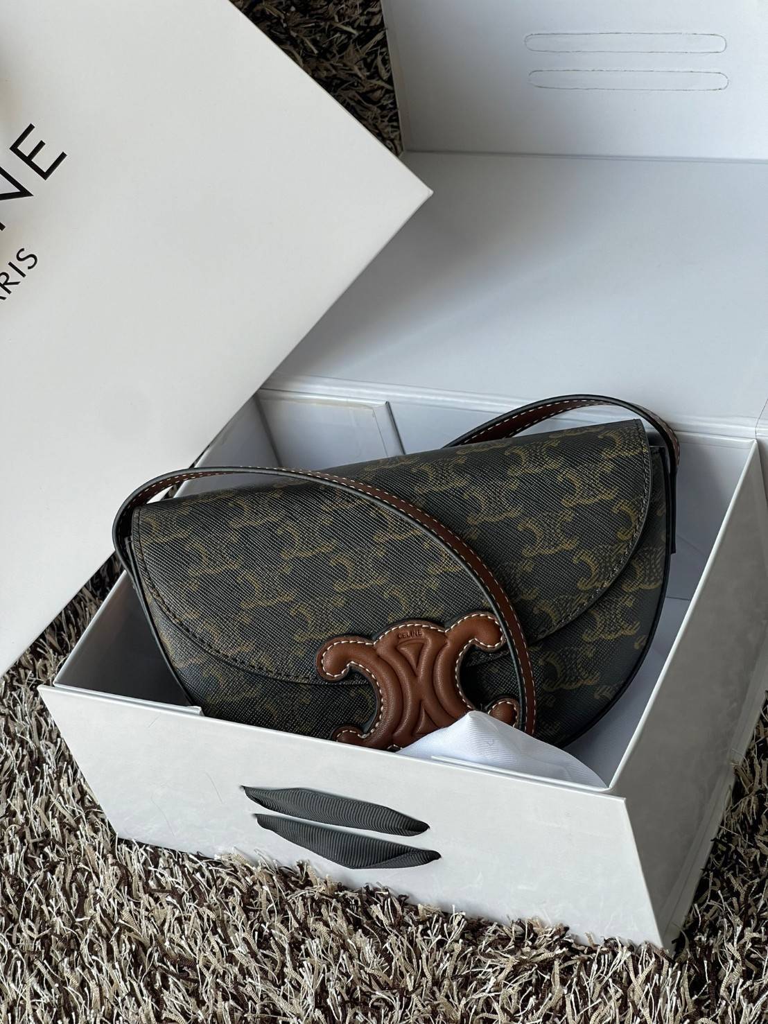 CELINE BESACE CUIR TRIOMPHE IN SMOOTH กระเป๋ารุ่นนี้นำเสนอในรูปทรงฮาล์ฟมูนที่ตอนนี้กำลังงมาแรง เปิดด้วยกระดุมแป๊กเพื่อเผยให้เห็นช่องภายในที่กว้างขวางและกระเป๋าด้านในแบบแบน คุณสมบัติที่โดดเด่นอีกอย่างของกระเป๋าอยู่ที่โลโก้ขนาดใหญ่ รูปทรงสะดุดตา สามารถสะพาย