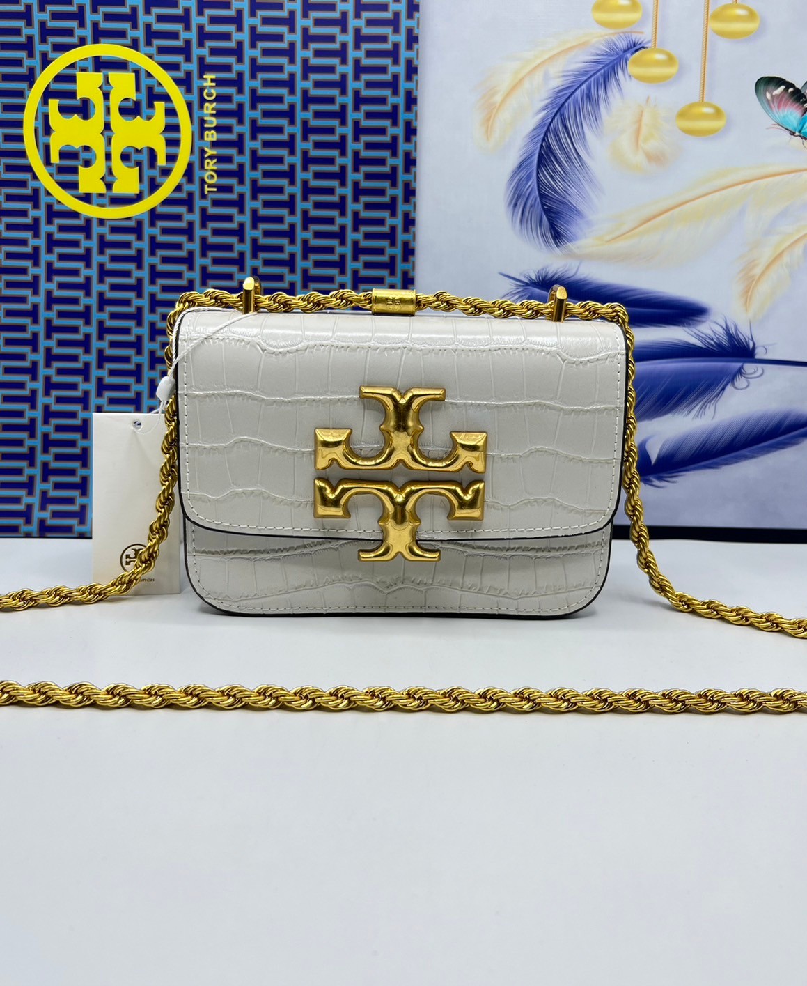 6 สี Tory Burch Croc Eleanor Small Bag / TORY BURCH ELEANOR CROC EMBOSSED LEATHER กระเป๋าสะพายหนังพิมพ์ลายจระเข้ ดีไซน์หรูหรา โด่นเด่นด้วยโลโก้แบรนด์อะไหล่ด้านหน้า และสายสะพายโลหะสีทอง