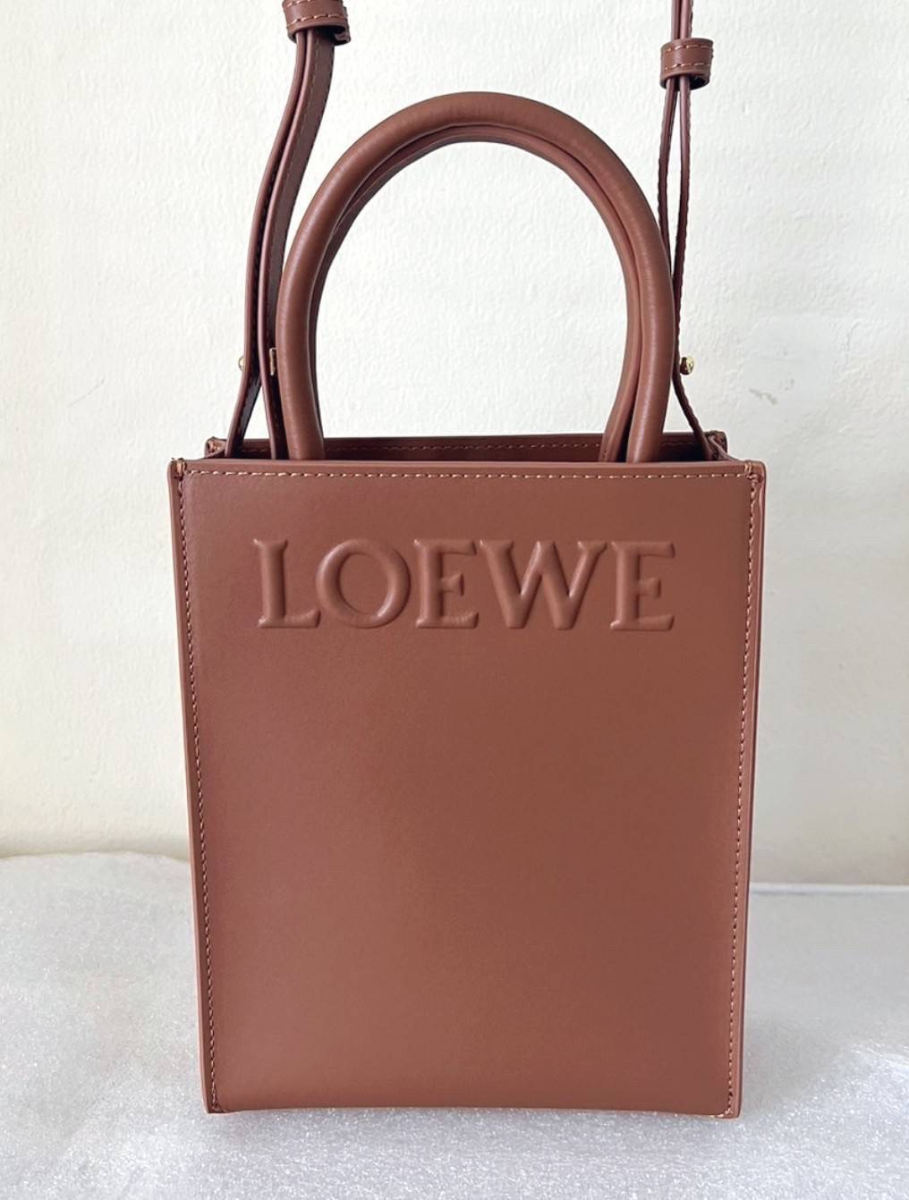 LOEWE Tote Leather Bag พร้อมส่ง กระเป๋าทรงโท้ทหนังเรียบสวยอยู่ทรงด้านหน้ามีโลโก้แบรนด์ หูจับแข็งแรงมาพร้อมสายสะพายหนังเรียบยาวปรับระดับได้จะถือหรือสะพายไหล่สะพายเฉียงก็ดูดี