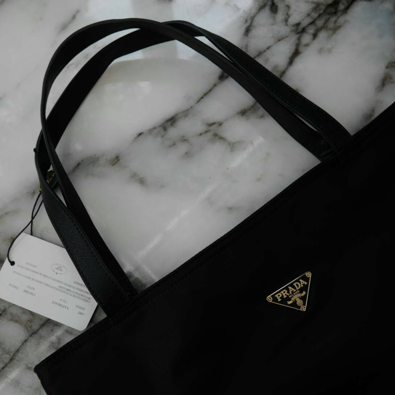 ReStock! งานขายดี ได้ กระเป๋าสะพายไหล่ ทรง TOTE จากแบรนด์ PRADA มาค่า เป็น กระเป๋าผ้าไนล่อน ตามแบบฉบับของแบรนด์เลย ใบนี้มีสายยาวให้ค่ะ สะพายเป็น shoulder bag หรือ ถือได้ค่ะ ด้านหน้าเป็นลายหมี ปักกลิ้ตเตอร์ +logo brand ใช้แล้วสวยมากๆ อะไหล่ทองหรูมาก จุของค
