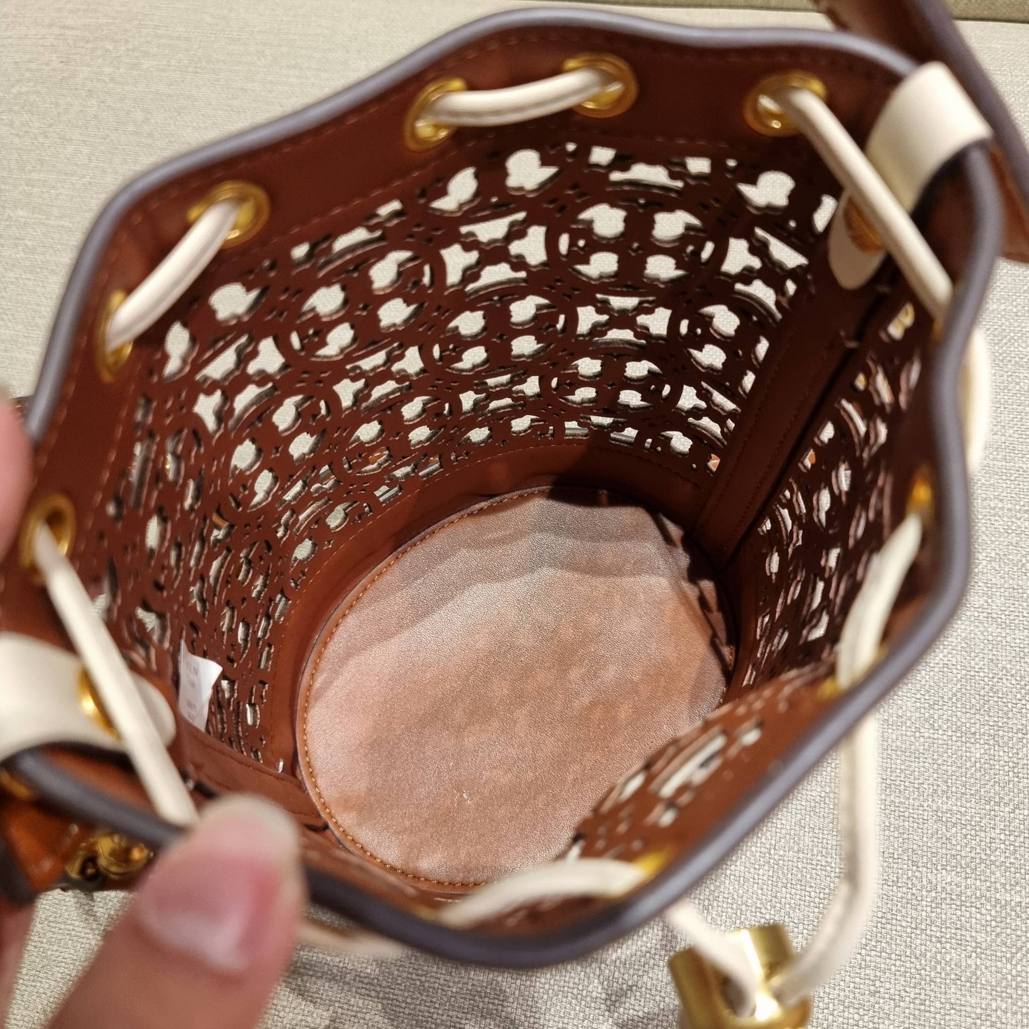 TORY BURCH T MONOGRAM LASER-CUT MINI BUCKET BAG ใจบางที่สุดกับคอลเลคชั่นนี้ กับกระเป๋าสะพายทรงบัคเก็ต ไซส์มินิ รุ่นชูโรงสุดฮิต ที่เพิ่มดีเทลความแพงด้วยการฉลุลวดลายโมโนแกรมรอบใบ ถักทอเป็นเส้นลายสานที่สวยงามมาก งานฝีมือจริงๆ วัสดุหนัง cowhide รูดเปิด-ปิดด้ว