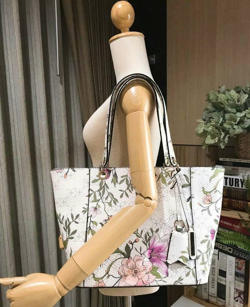 GUESS PRINTED KAMRYN FLOWERS SHOPPER BAG (SIZE L) กระเป๋าสะพายจาก GUESS FACTORY หนังสวยอยู่ทรงปริ้นลายดอกไม้คอลเลคชั่นล่าสุดใบใหญ่กำลังดี ใส่สัมภาระได้จุใจ น้ำหนักเบา ด้านหน้าประดับโลโก้แบรนด์อะไหล่เงินพร้อมพวงกุญแจแบรนด์ห้อยที่หูหิ้วถอดเเยกใช้ได้ หูหิ้วพ