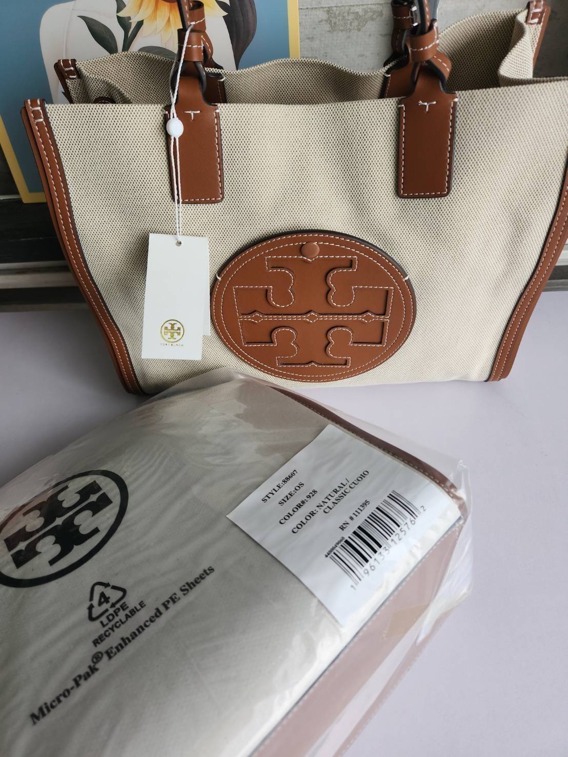 TORY BURCH ELLA CANVAS TOTE BAG กระเป๋าโท้ตน้ำหนักเบาของเราพร้อมป้ายโลโก้ Ella ทำจากผ้าใบที่ทนทานพร้อมรายละเอียดหนังและกระเป๋าด้านใน อเนกประสงค์ ทรงคลาสสิก และสร้างขึ้นอย่างสวยงามด้วยฝีมือช่างฝีมือ สายรัดแคบช่วยให้วางราบกับไหล่ได้อย่างสบาย เหมาะสำหรับทุกว