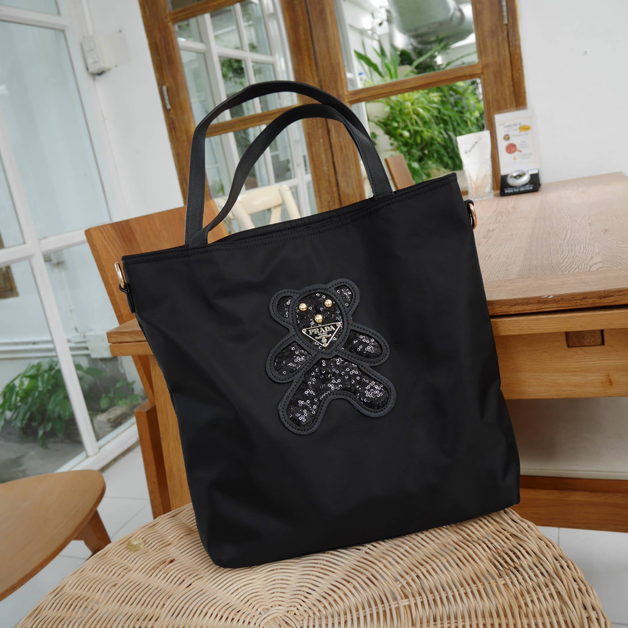 งานขายดีคะ ♡♡ กระเป๋าสะพาย ทรง TOTE จากแบรนด์ PRADA มาค่า ตัวกระเป๋าเป็น nylon ทั้งใบ สะพายเป็น shoulder bag หรือถือได้ค่ะ ด้านหน้าเป็นลายหมี ปักกลิ้ตเตอร์ + logo brand ใช้แล้วสวยมากๆ อะไหล่ทองหรูมาก จุของคุ้ม ใส่หนังสือ หรือ MacBook ได้ค้า 