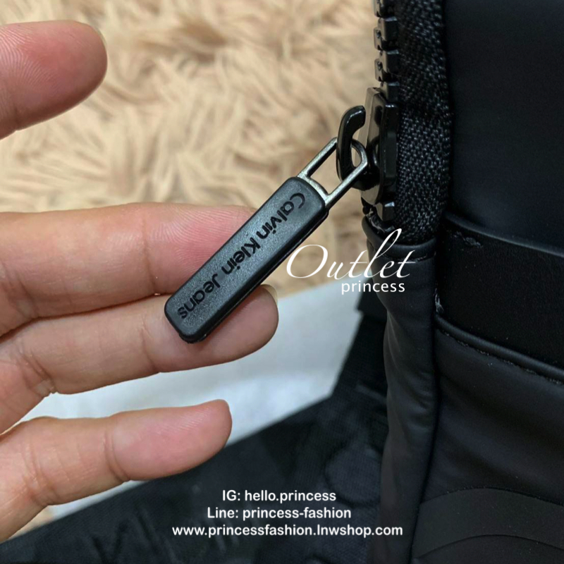 Cavin Klein Crossbody Bag กระเป๋าสะพายข้าง วัสดุหนังโพลีเอสเตอร์ น้ำหนักเบา สายสะพายปั้กโลโก้ ปรับความยาวได้ฟรีไซส์ ด้านหน้ามี1ช่องซิปใส่ของได้ หัวซิปปั้มโลโก้ทุกจุด เปิดปิดด้วยซิปเดียวด้านบน ด้านหน้ามีโลโก้เป็นอักษรย่อสวยงาม ขนาดกระเป๋าใส่มินิไอแพคกระเป๋