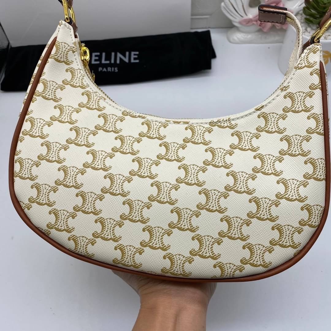 หนังแท้ CELINE AVA / CELINE Vintage Classic Ava bag 1 ใน คอลเลคชั่น “Triomphe Canvas” มาพร้อมสายสะพายไหล่ที่ปรับความยาวได้ และเนื่องจากช่วงล่างของกระเป๋ามีขนาดใหญ่กว่าช่วงบน จึงทำให้ไม่เสียทรงเมื่อเราใส่สิ่งของอย่างกระเป๋าสตางค์หรือโทรศัพท์มือถือ หากดูภาพ