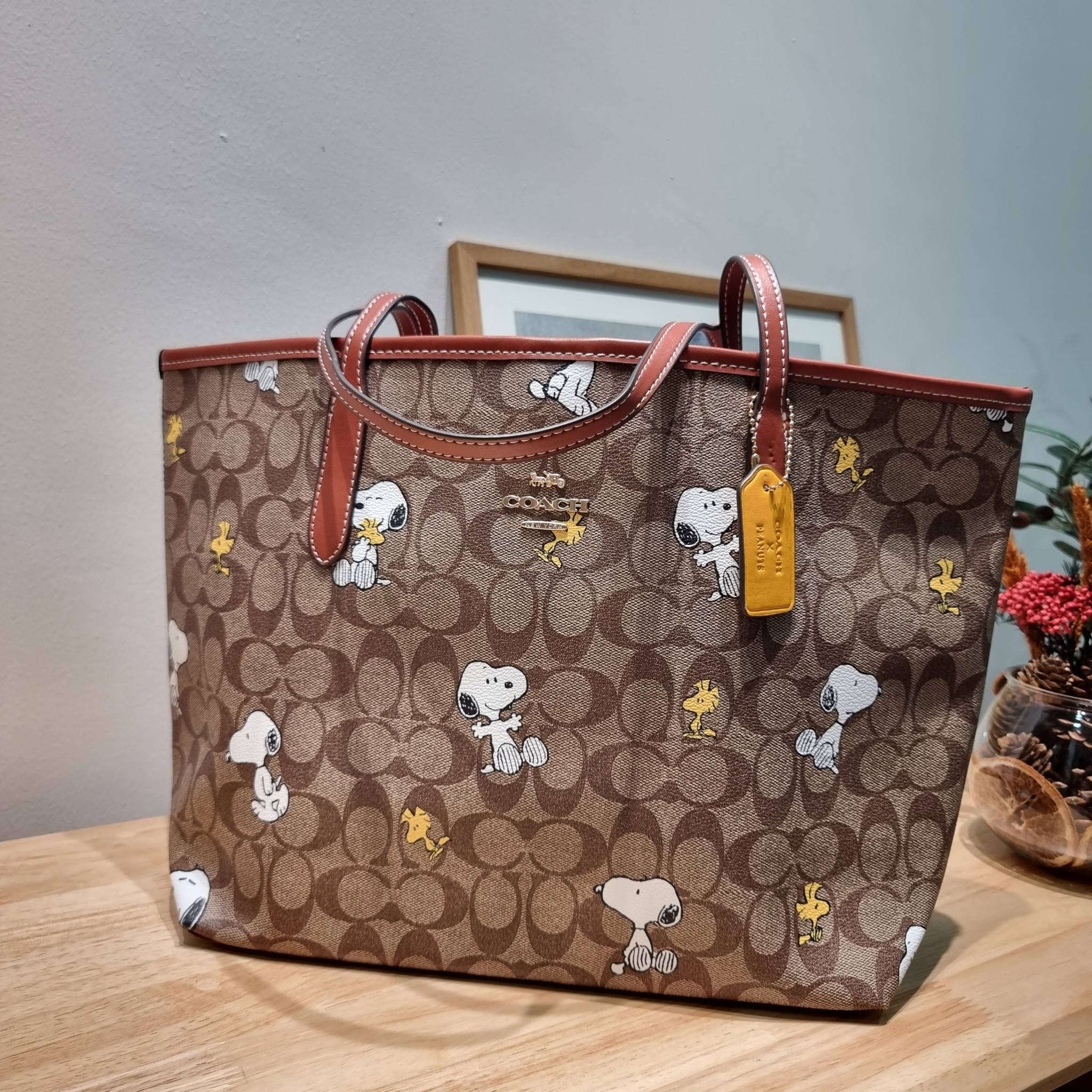 Coach X Peanuts City Tote In Signature Canvas With Snoopy Woodstock Print CF166 คอลเลคชั่นใหม่ น่ารักเกินต้าน กับกระเป๋าทรงโท้ทไซส์ใหญ่ ดีไซน์ลวดลายการ์ตูนยอดฮิต ที่ใครๆก็ต้องรู้จัก พิมพ์คมชัดลงบนหนังแคนวาส รูปทรงสวย ปากกระเป๋ามีกระดุมแม่เหล็กปิดกันของหล่