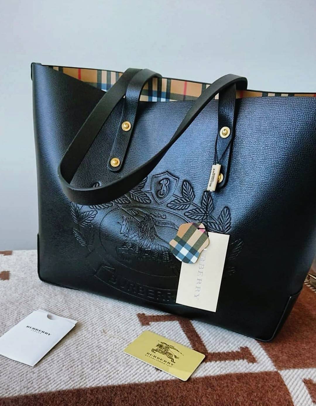 VIP 🥂 BURBERRY FRAGRANCES TOTE BAG VIP รุ่นแนะนำ ดีไซน์สวยโดดเด่นหนังสีดำขึ้นเทคเจอร์ด้านหน้ามีโลโล้แบรนด์ ภายในลายวินเทจสุดคลาสสิค โล่งกว้างมีช่องซิปเล็กและโลโก้ด้านใน สามารถใส่เอกสาร A4 Notebook ipad สัมภาระได้เยอะจุใจ หูหิ้วหนังจับถนัดมือสะพายไ