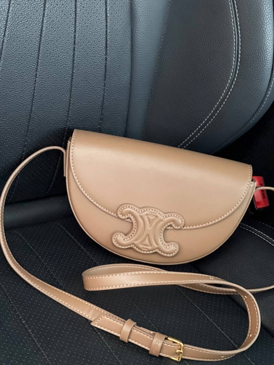 CELINE BESACE CUIR TRIOMPHE IN SMOOTH กระเป๋ารุ่นนี้นำเสนอในรูปทรงฮาล์ฟมูนที่ตอนนี้กำลังงมาแรง เปิดด้วยกระดุมแป๊กเพื่อเผยให้เห็นช่องภายในที่กว้างขวางและกระเป๋าด้านในแบบแบน คุณสมบัติที่โดดเด่นอีกอย่างของกระเป๋าอยู่ที่โลโก้ขนาดใหญ่ รูปทรงสะดุดตา สามารถสะพาย